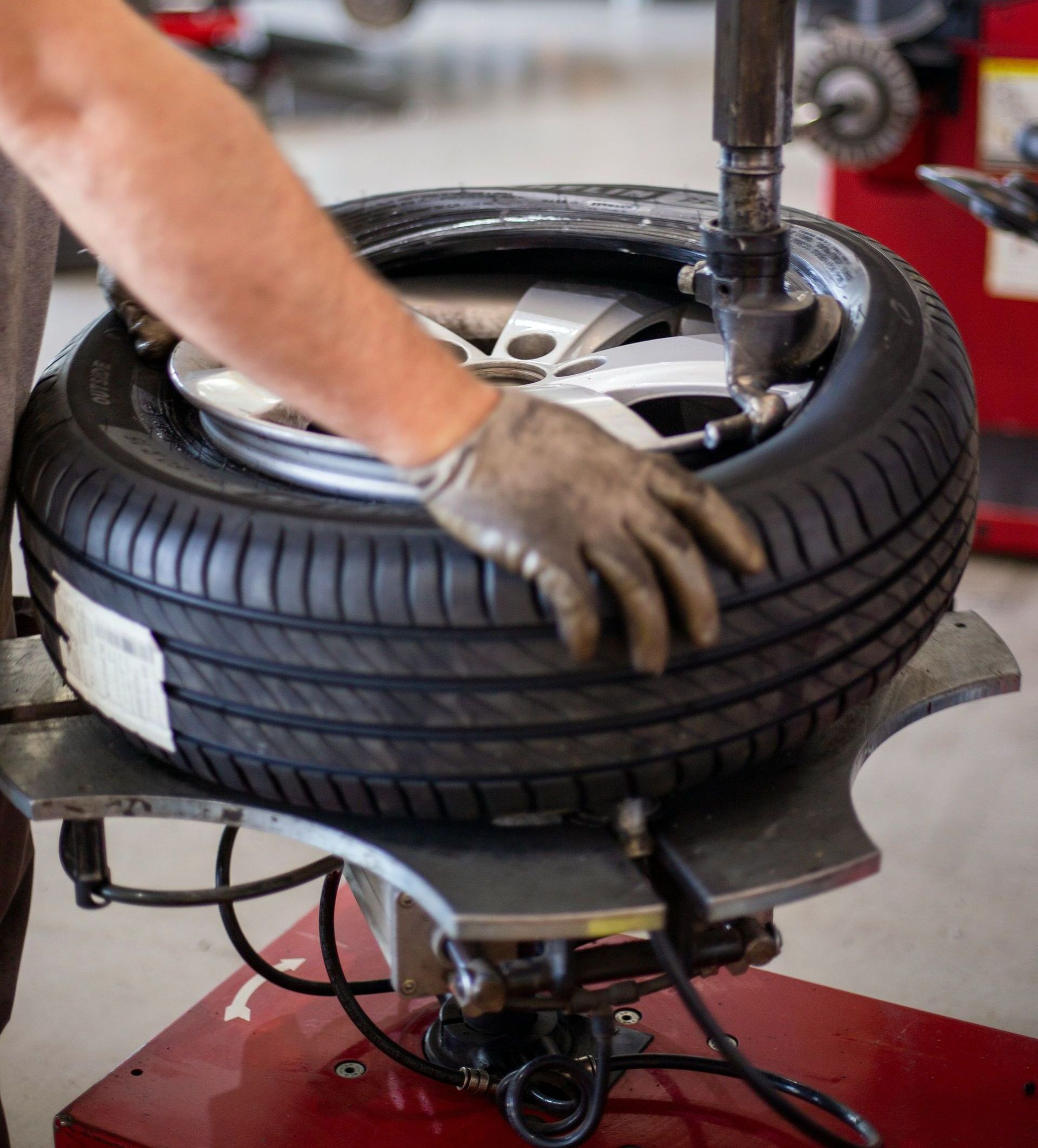 A person is changing a tire on a machine