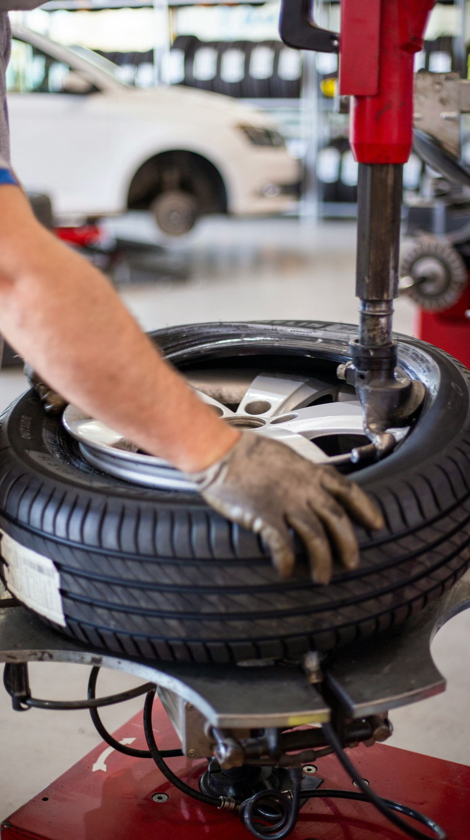 Mechanic using a tire machine to change a tire in a garage.