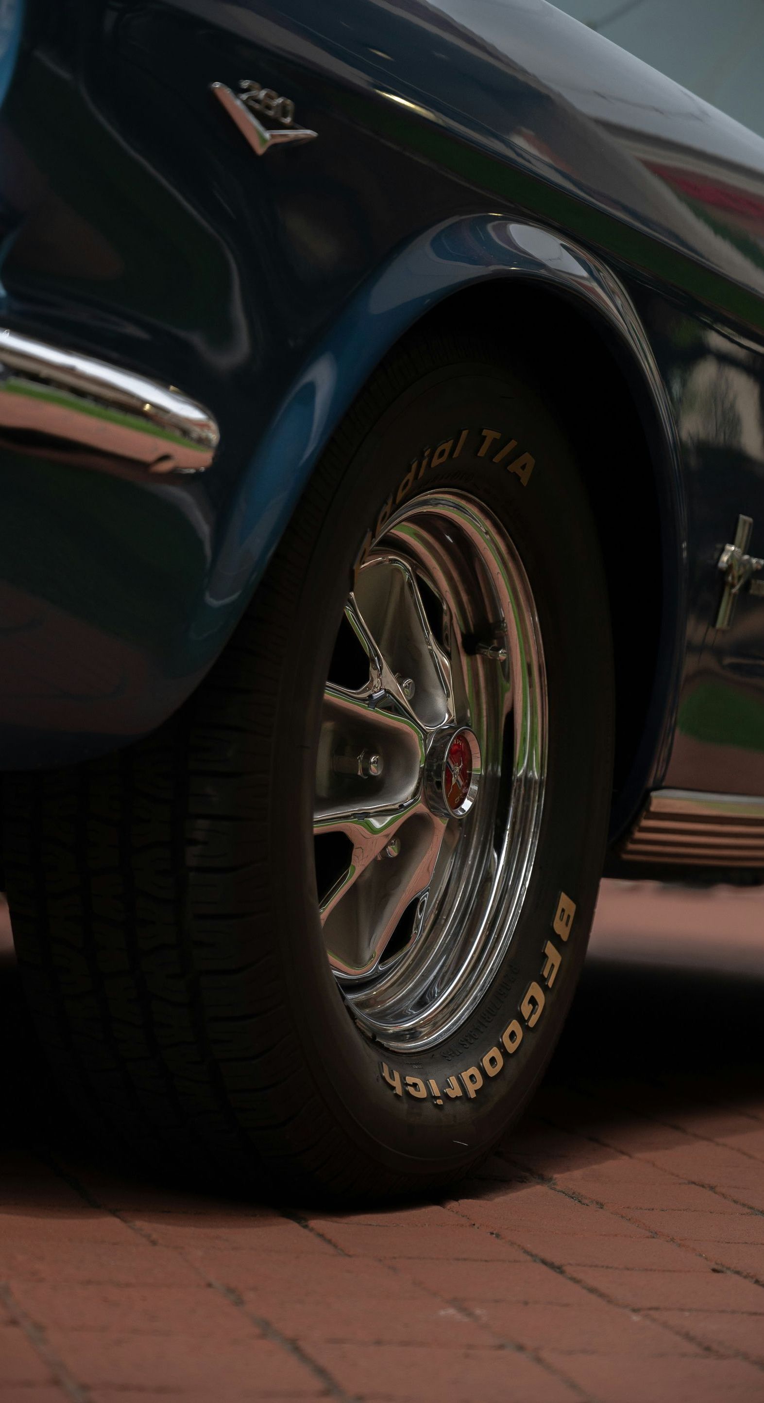 A close up of a car wheel on a brick road.
