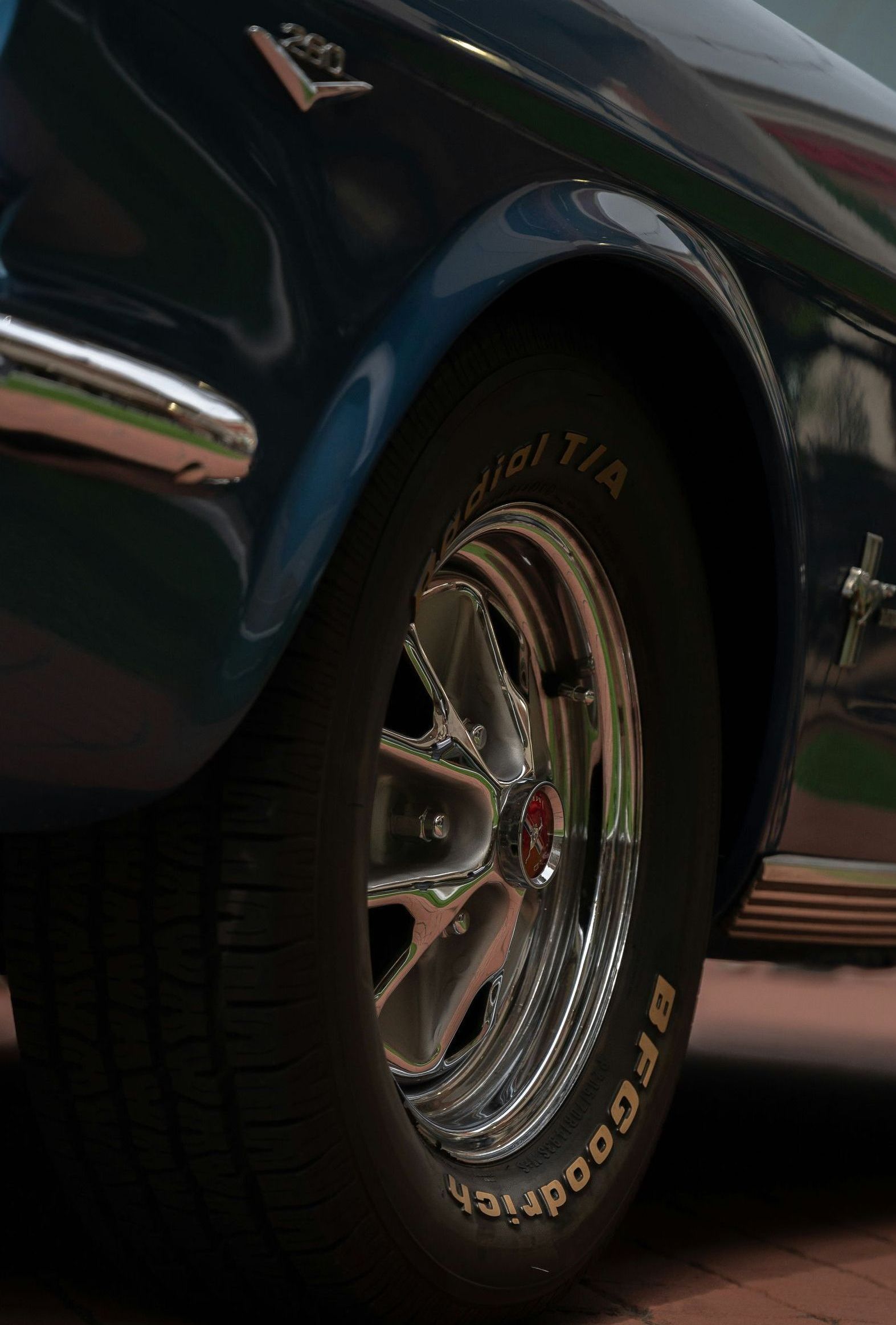 A close up of a car wheel on a brick road.