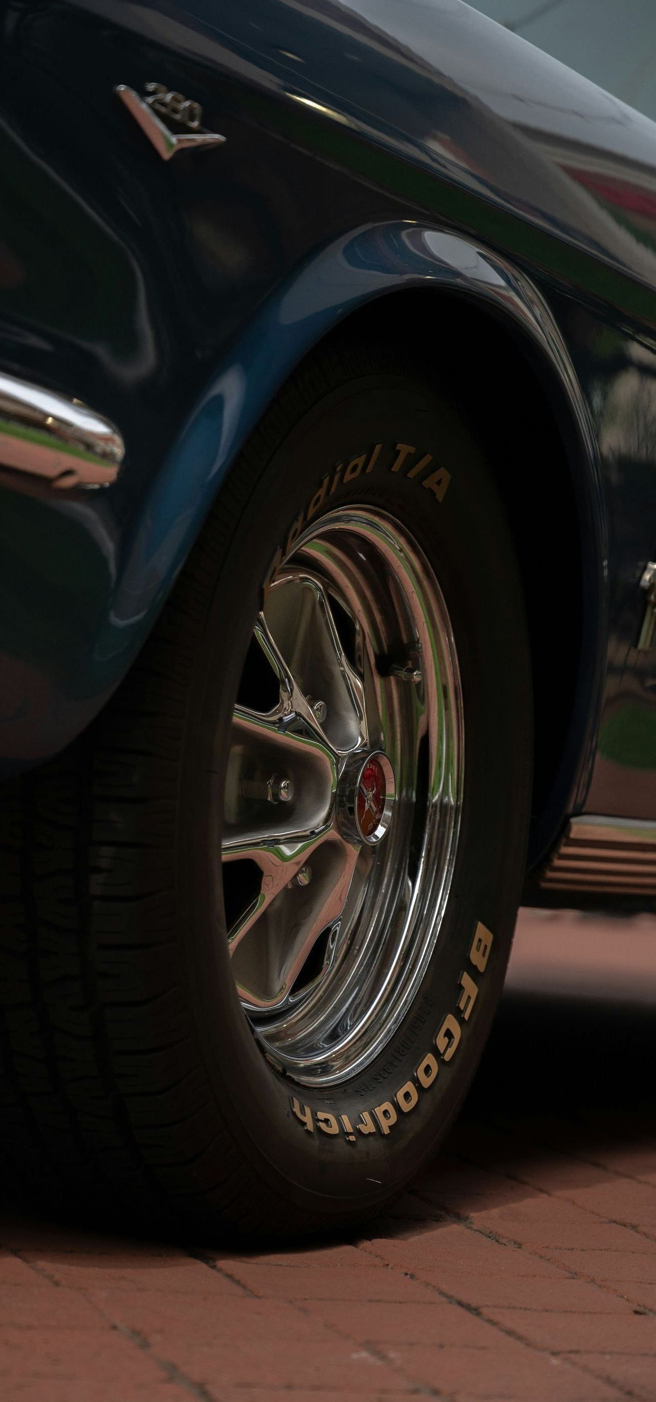 A close up of a car wheel on a brick road.