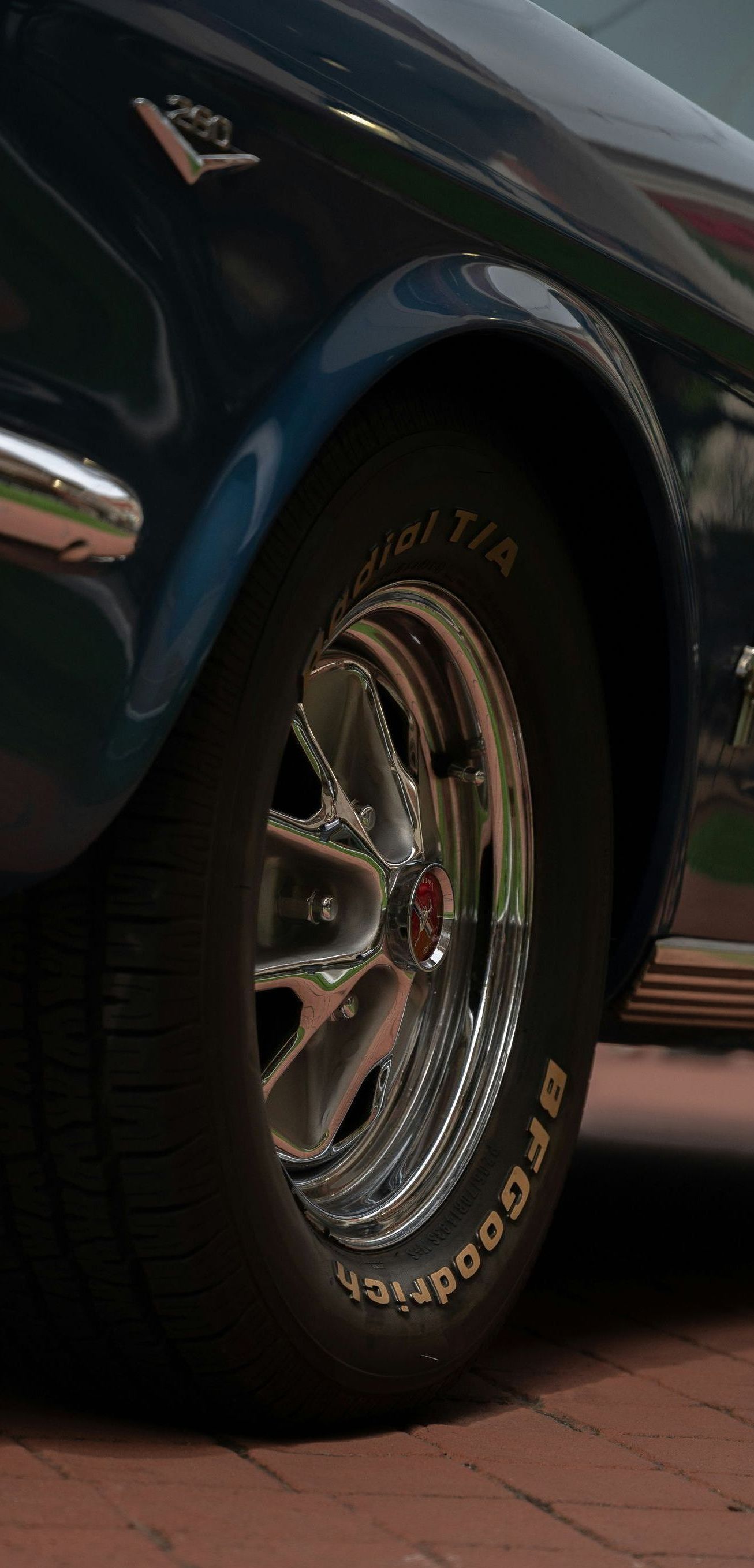 A close up of a car wheel on a brick road.