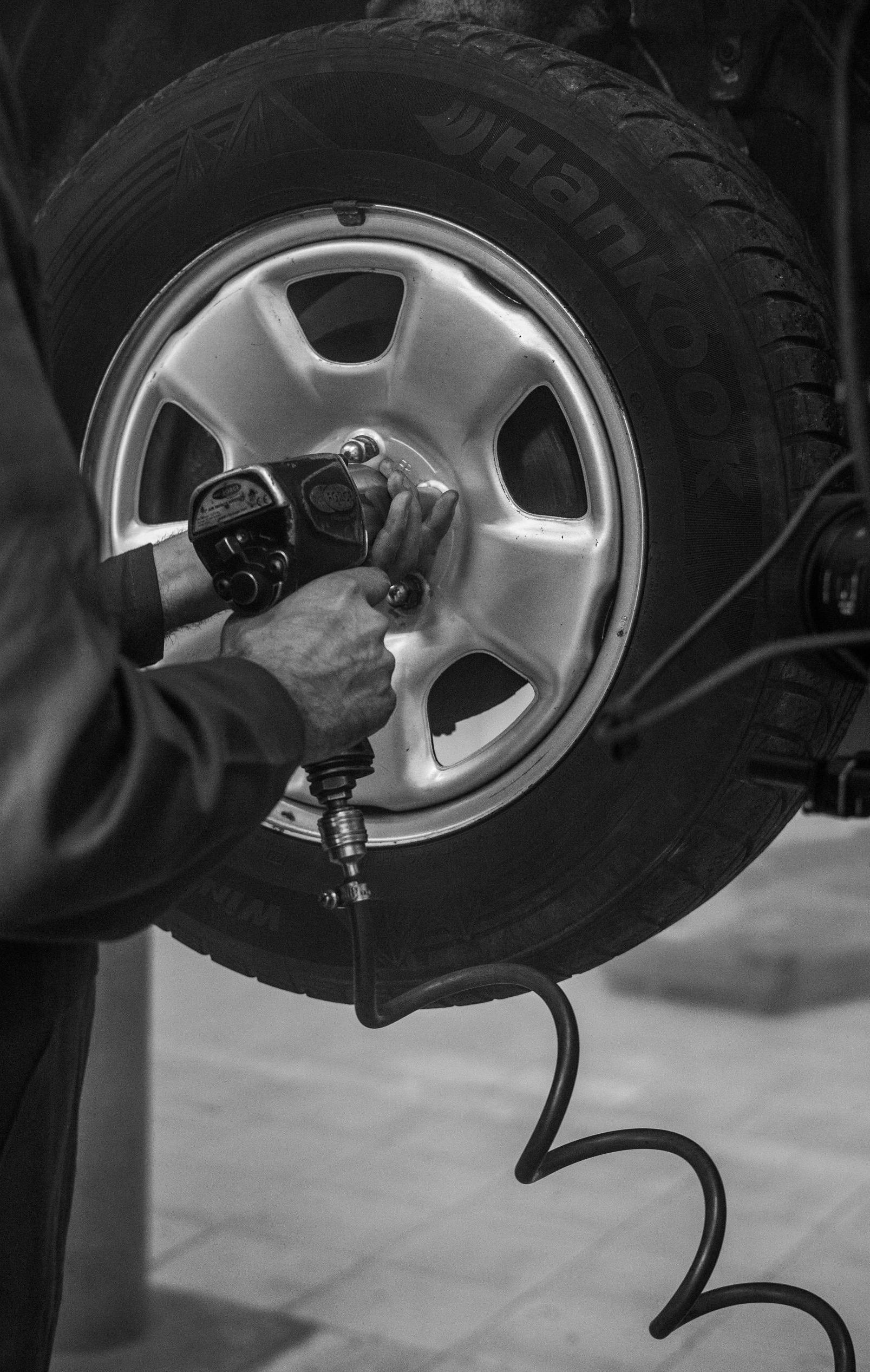 A black and white photo of a man changing a tire