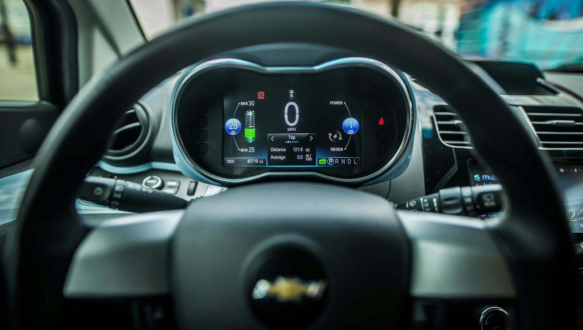 Dashboard of a Chevrolet Spark EV electric car with digital display showing driving information.