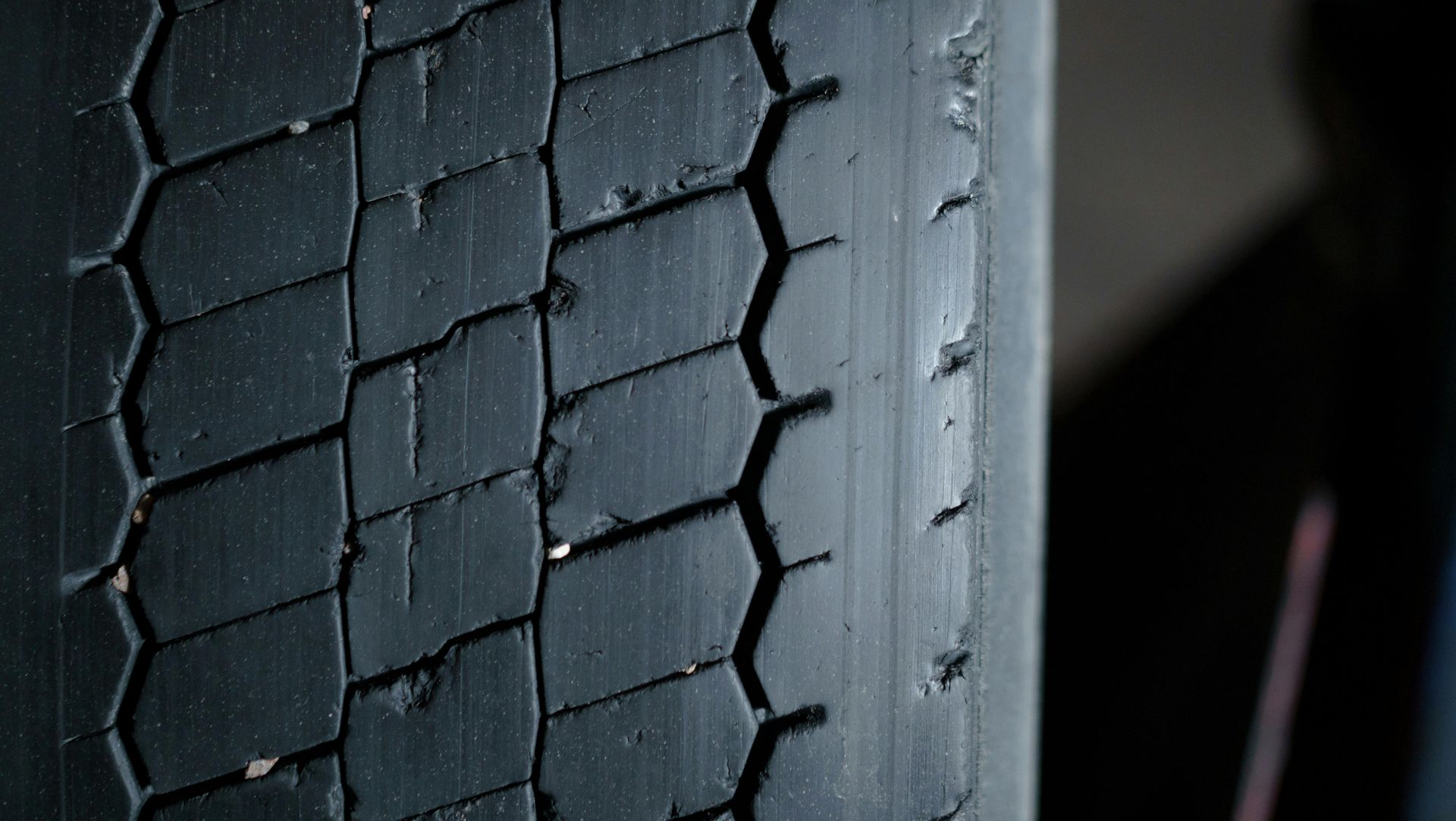 Close-up of a worn tire with a textured tread pattern, showing wear and tear.