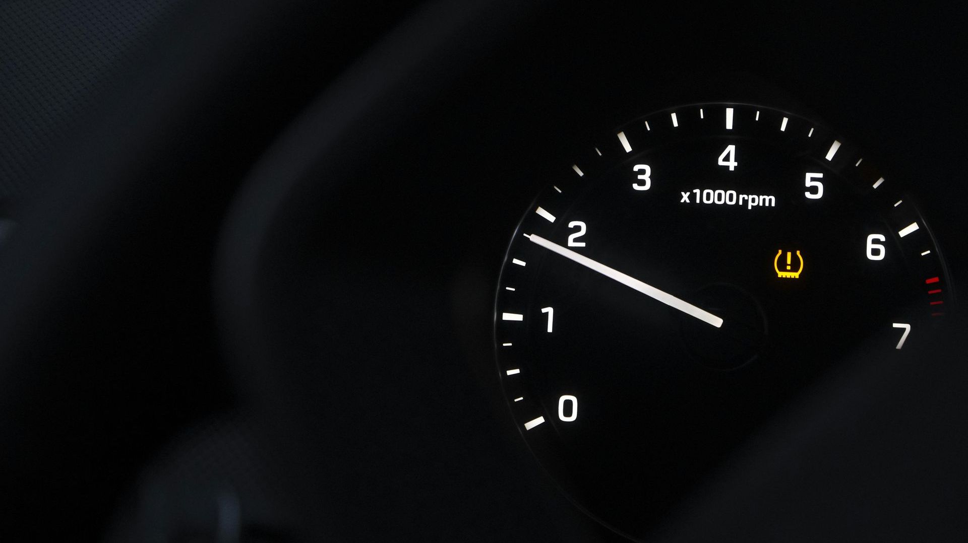 A close up of a car tachometer with the number 3 on it