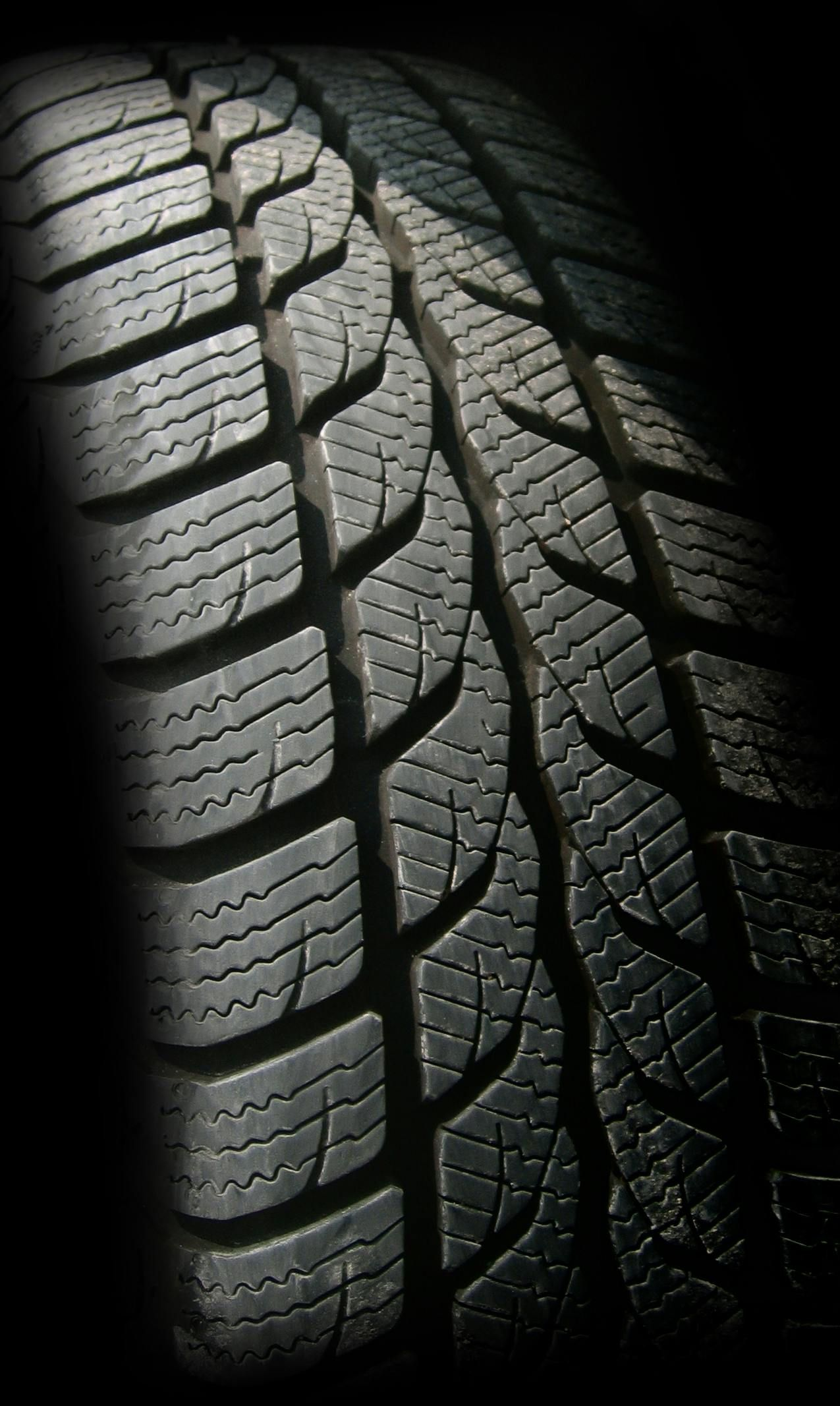 Close-up of a black tire with deep tread patterns.