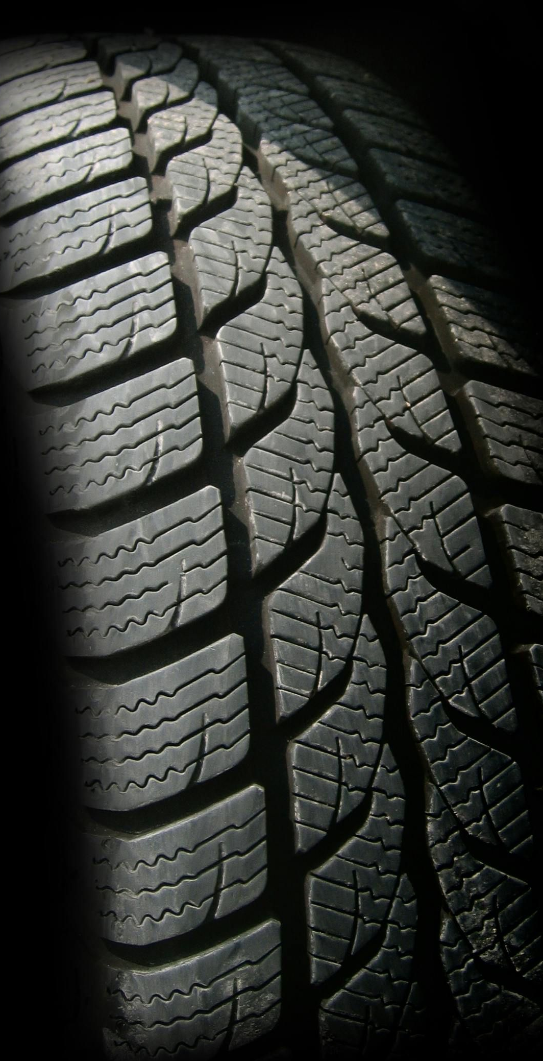 Close-up of a black tire with deep tread patterns.