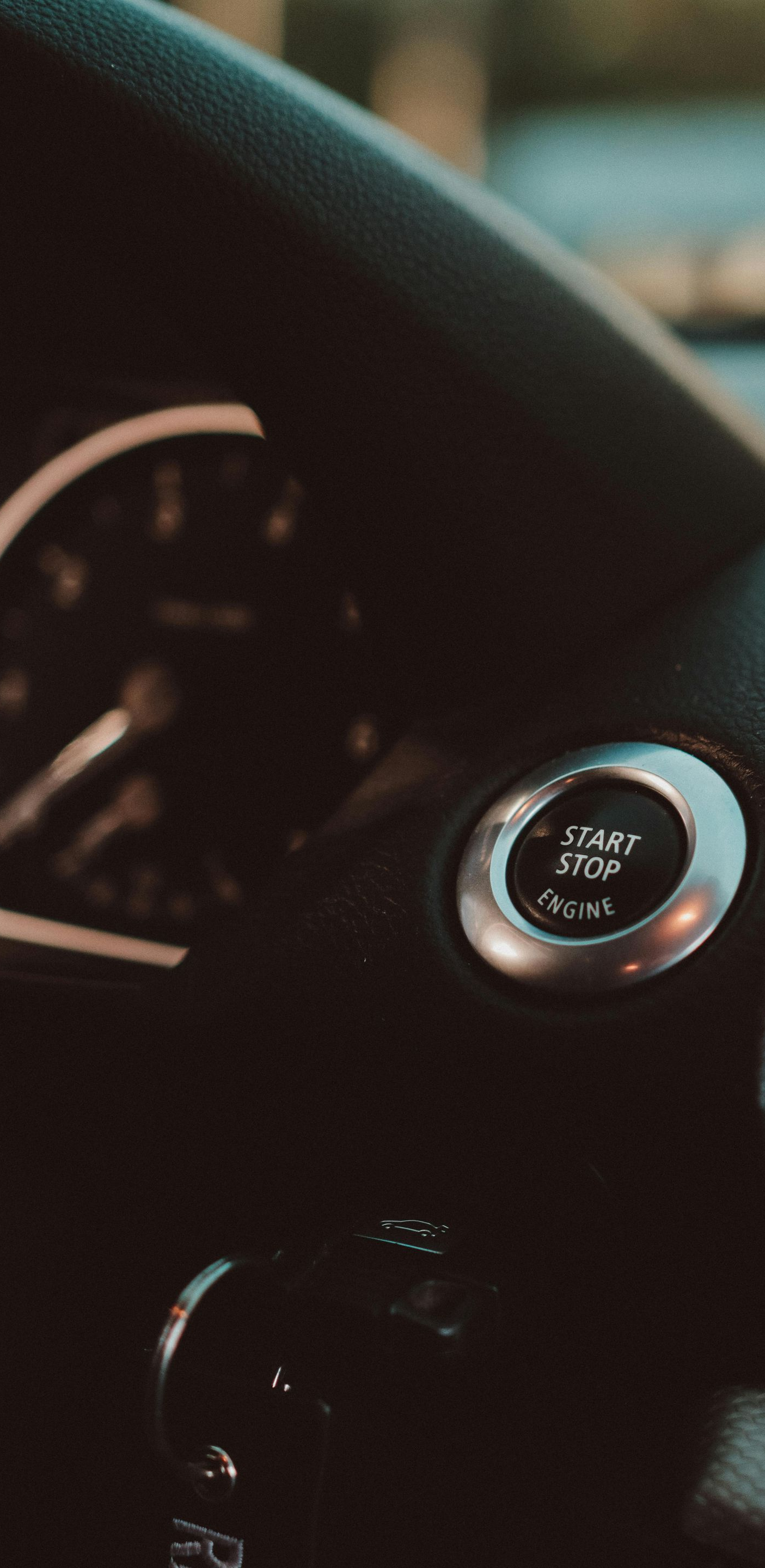 Dashboard with a start/stop button and speedometer in a car.