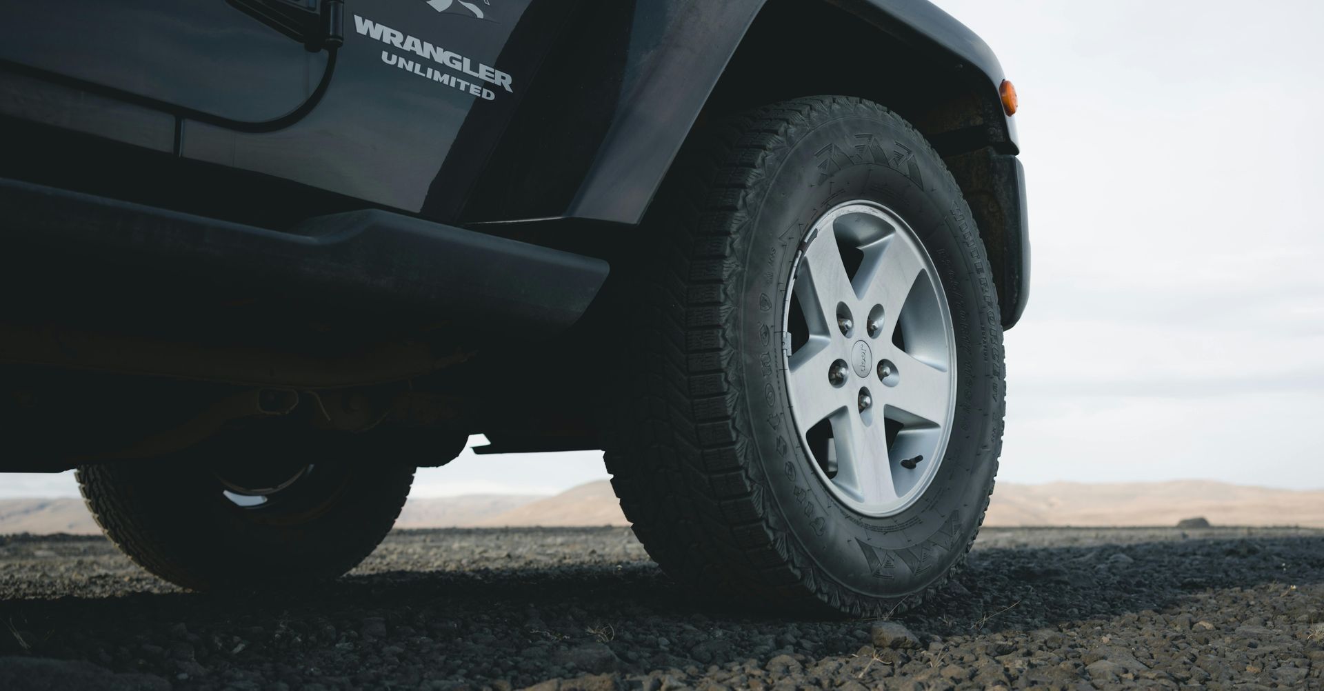 A black jeep is parked on the side of the road.