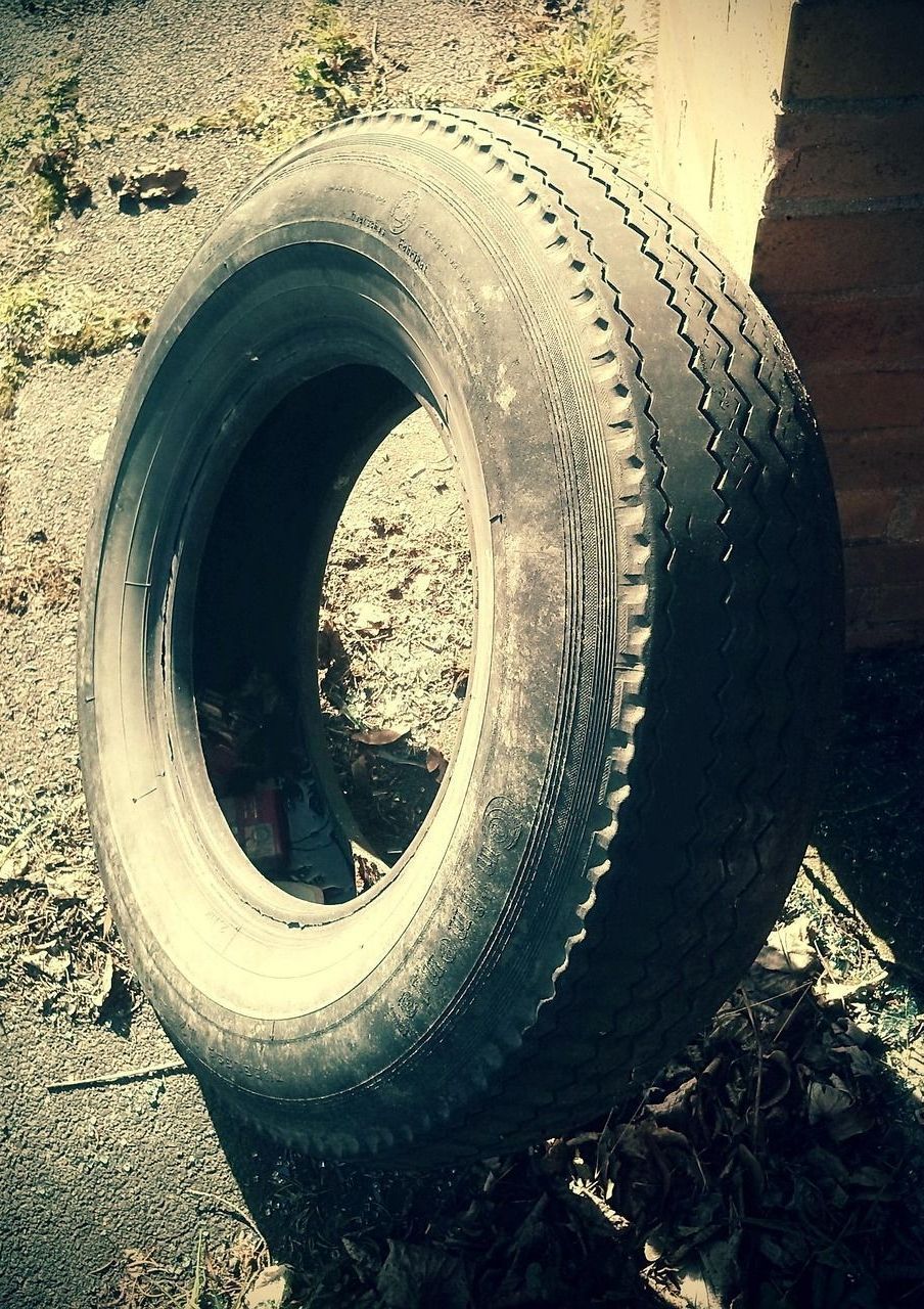A tire is sitting on the ground in front of a brick building