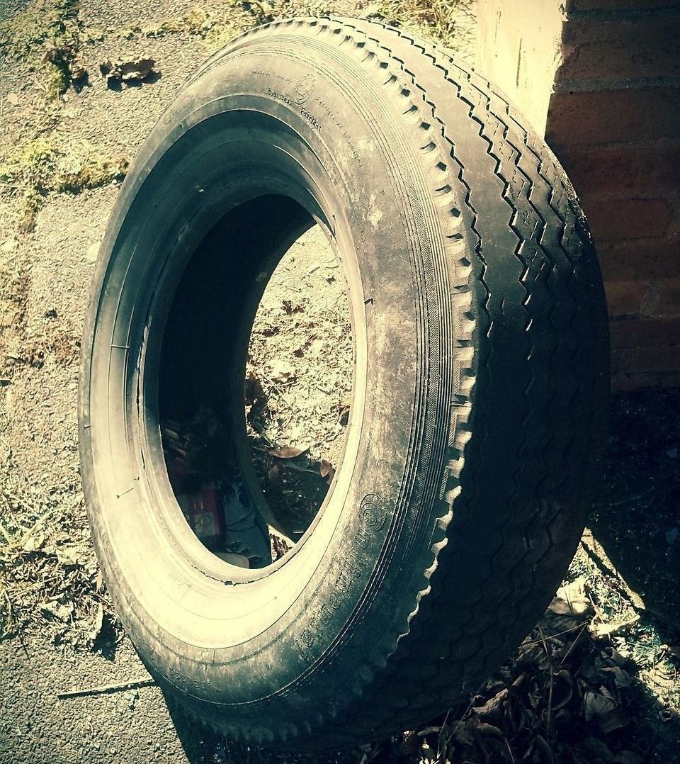 A tire is sitting on the ground in front of a brick building