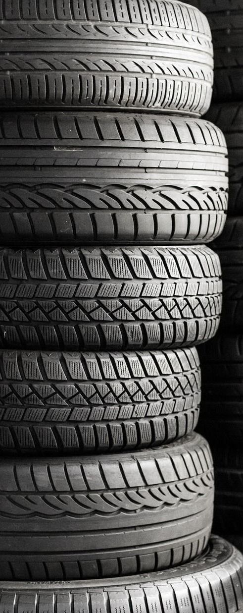 Stack of used tires in black and white.