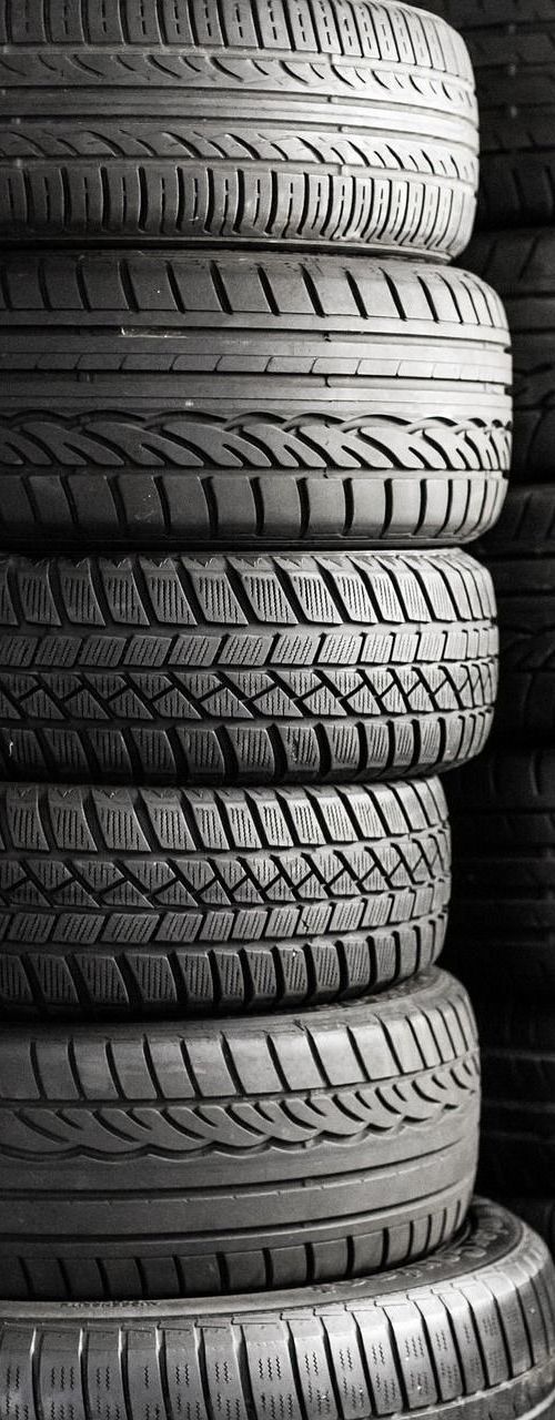 Stack of used tires in black and white.