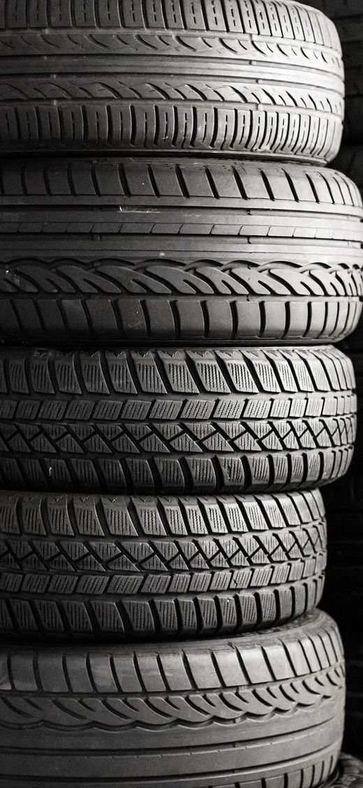 Stack of used tires in black and white.