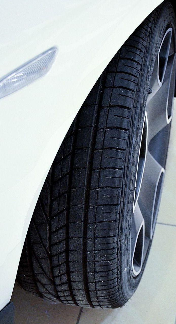 A close up of a tire on a white car