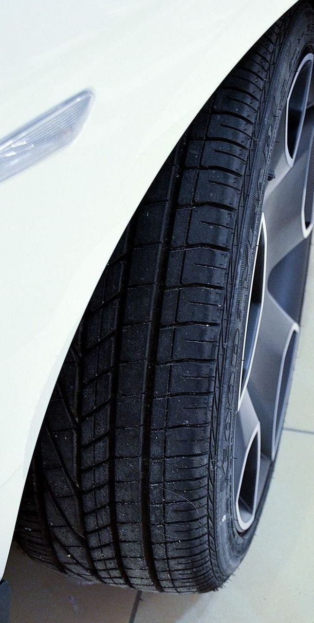 A close up of a tire on a white car