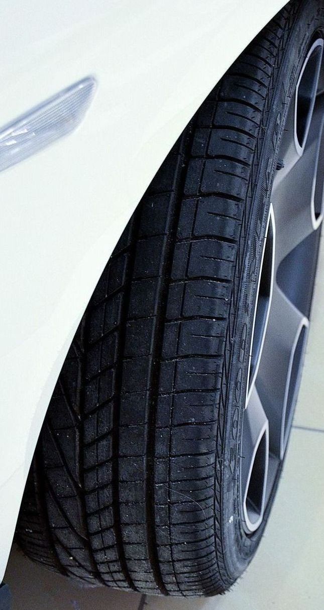 A close up of a tire on a white car