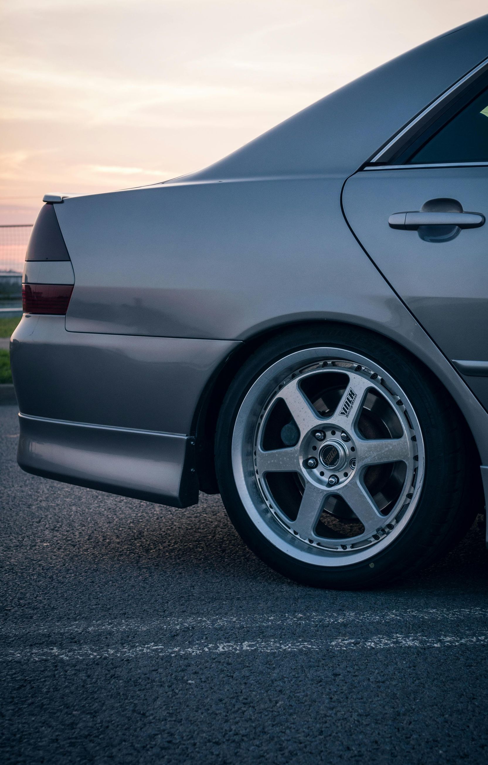 A close up of a car wheel on a brick road.
