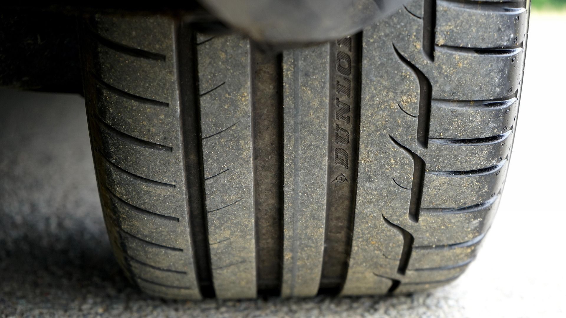 A close up of a dirty tire on a car.