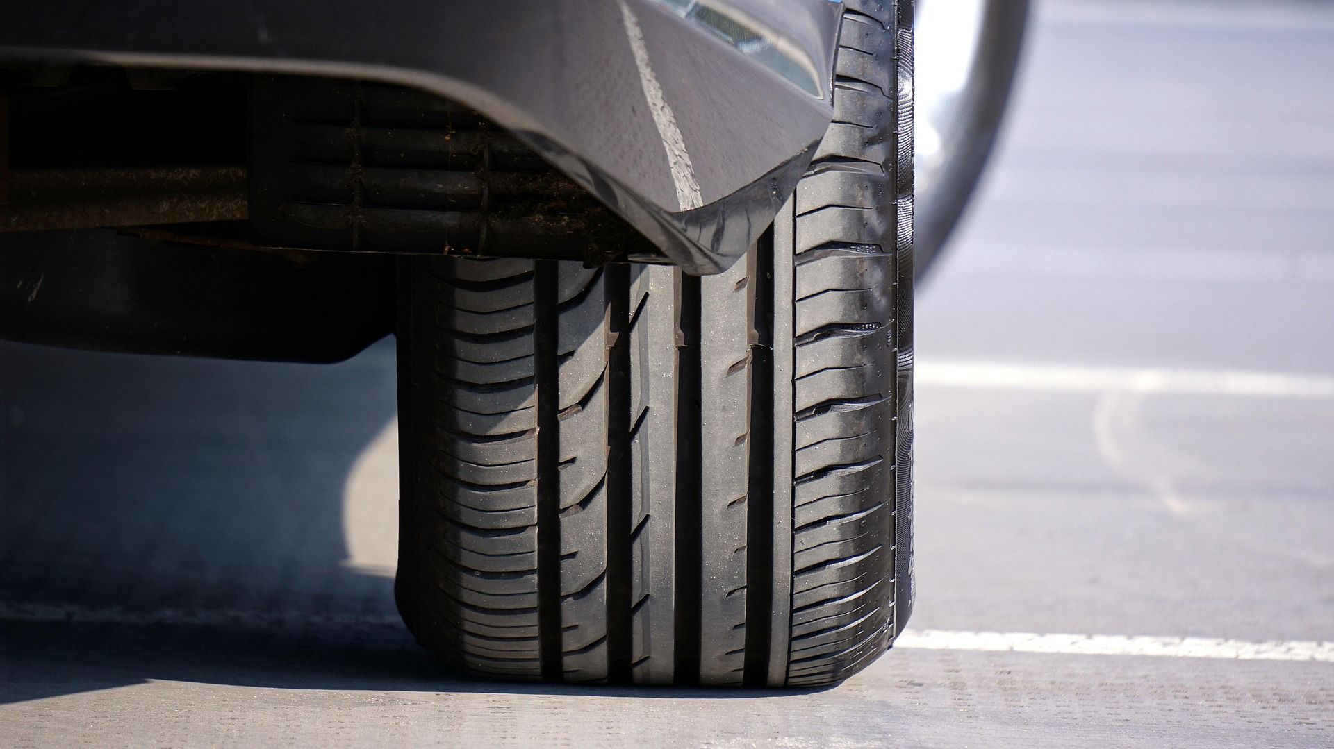 Close-up of a car tire on a concrete surface, showing tire tread.