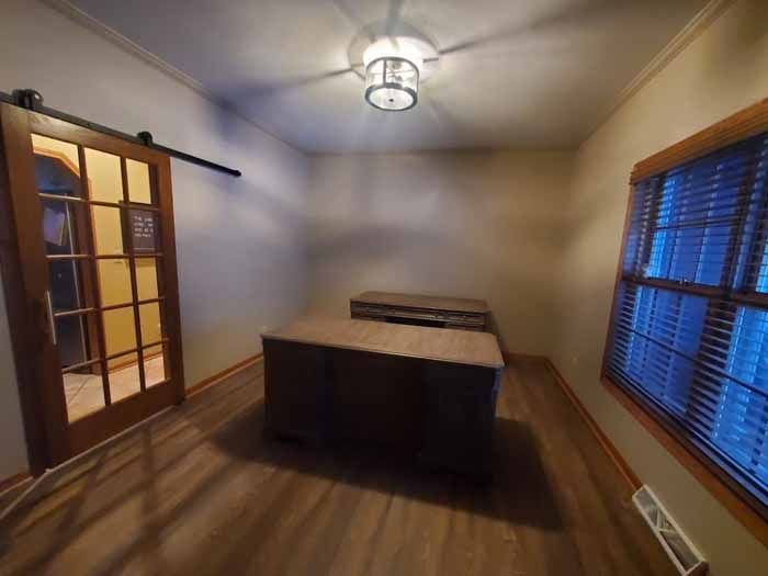 Empty room with a dark wood bed frame, blue blinds, and a ceiling light.