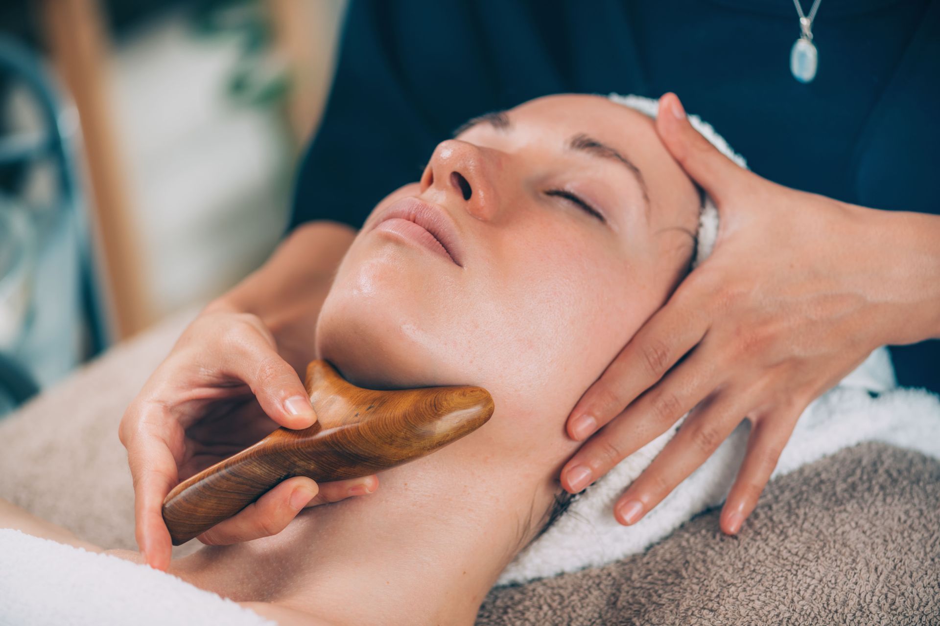 una donna sta ricevendo un massaggio al viso in un salone di bellezza .