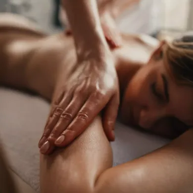 una donna è sdraiata su un letto e riceve un massaggio .