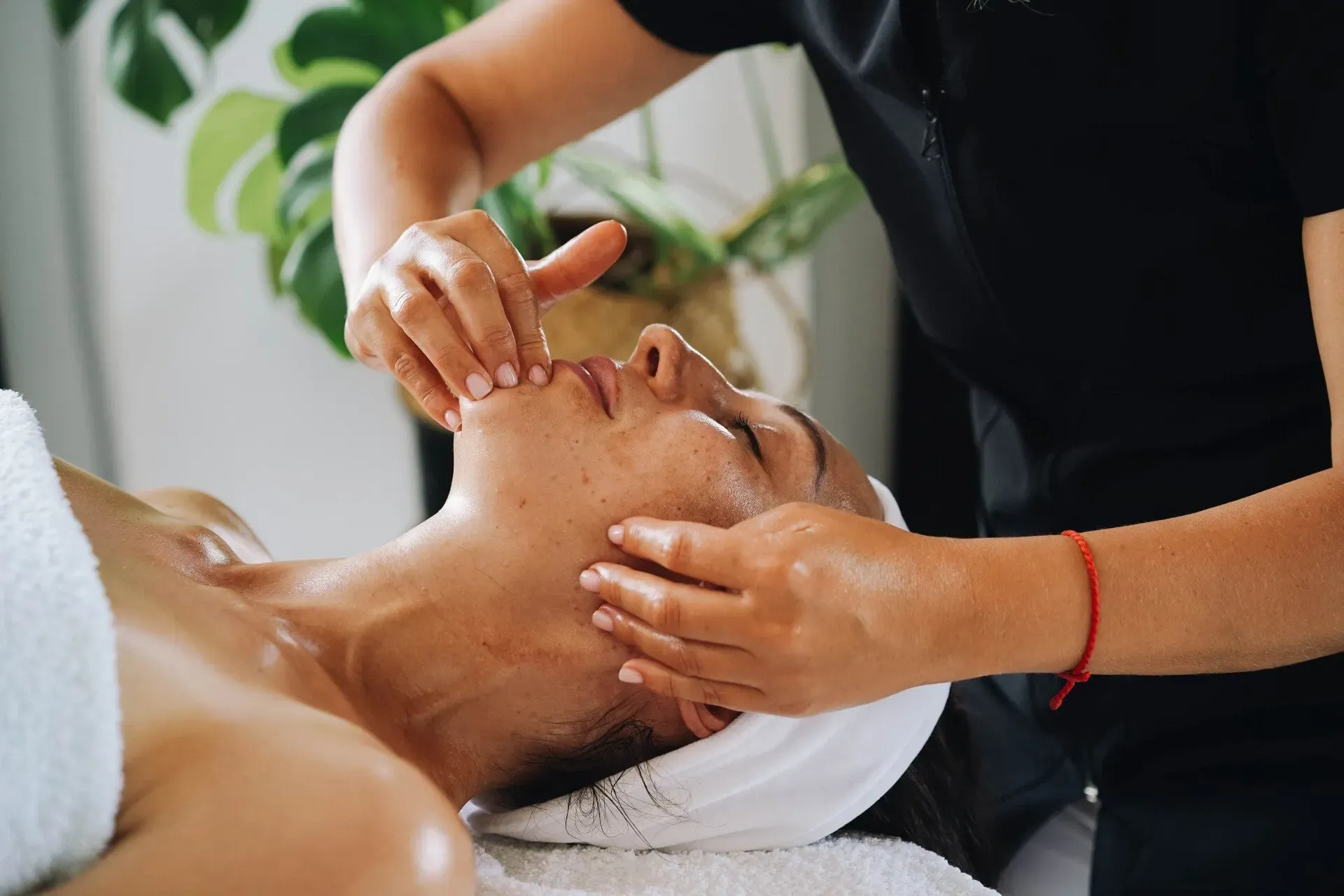 Una donna si sta sottoponendo a un massaggio facciale in una spa.