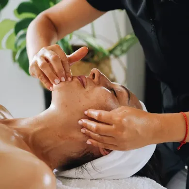 Una donna si sta facendo un massaggio al viso