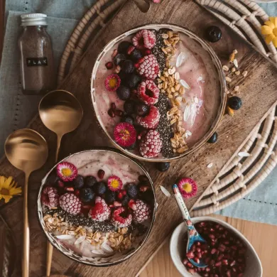 due ciotole di frutta e cereali su un tagliere di legno