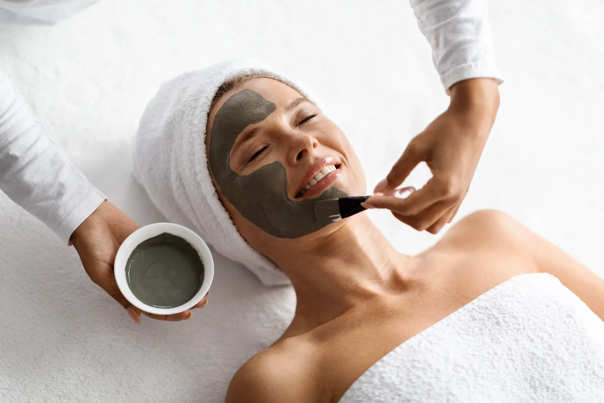 una donna sta ricevendo una maschera facciale in un salone di bellezza .