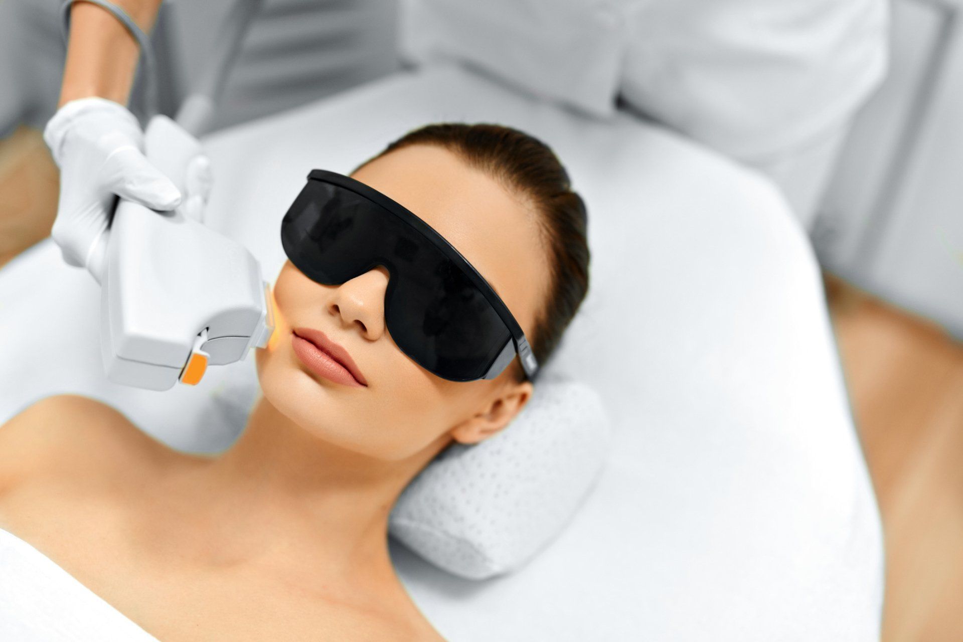 Woman in protective glasses receiving Intense Pulse Light treatment at Hot Springs Surgery and Vein