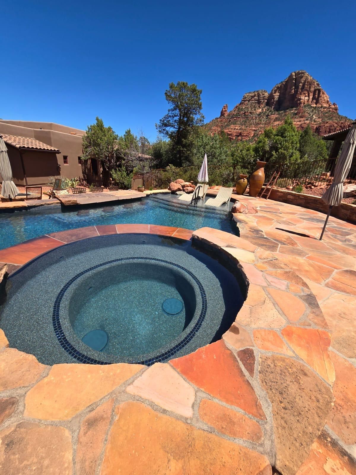 A large swimming pool with a hot tub in the middle