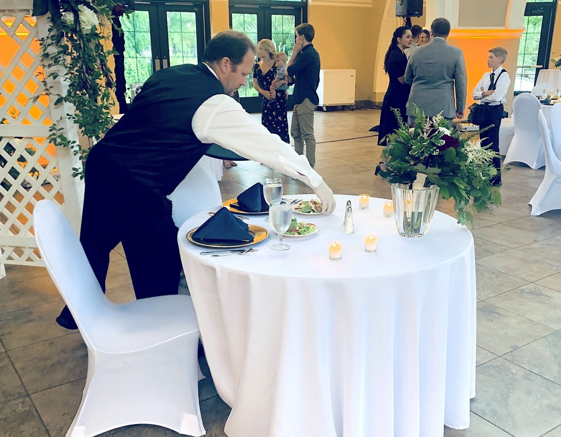 caterer serving salad to couples table