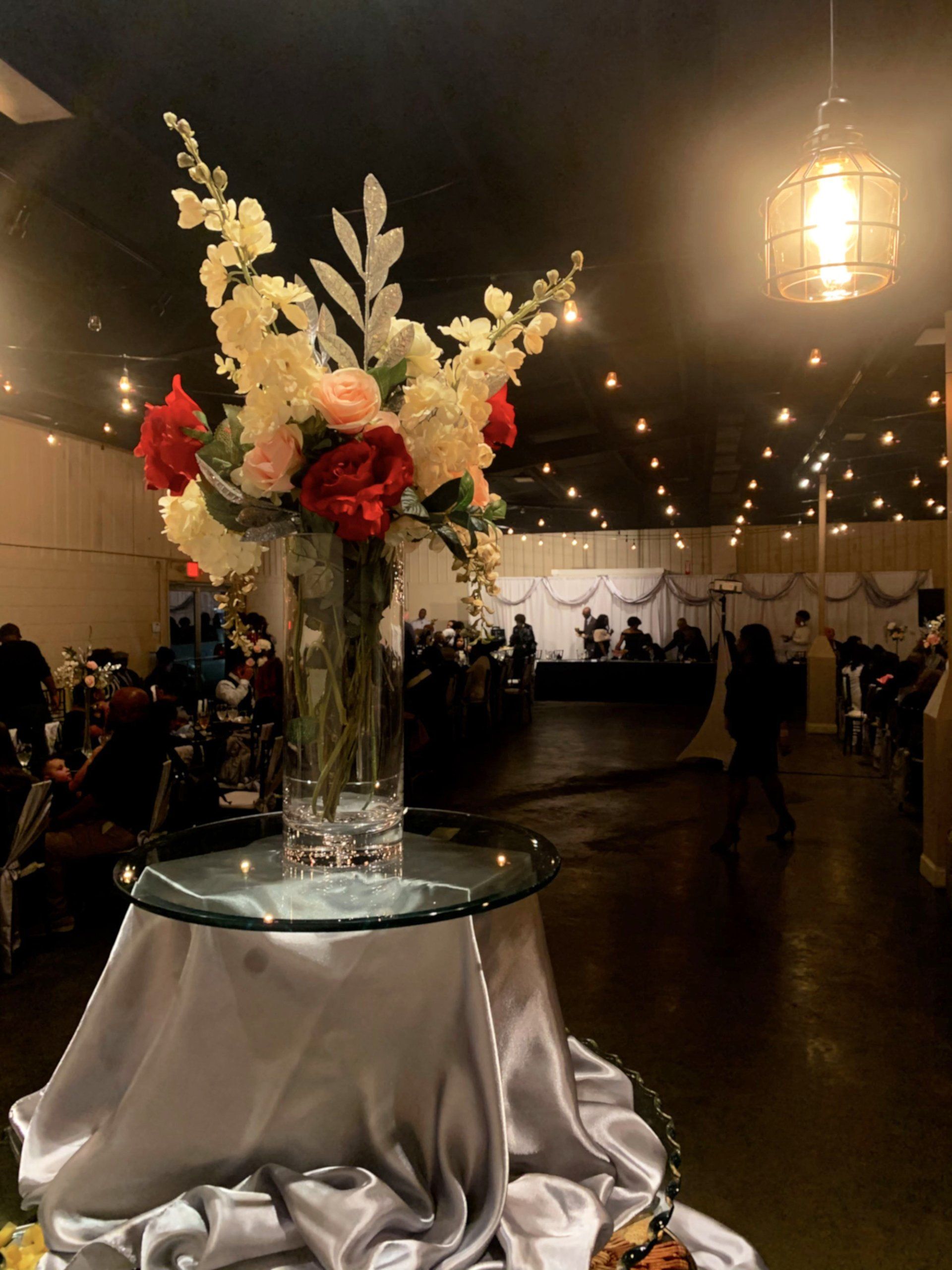 round glass table with tall floral centerpiece