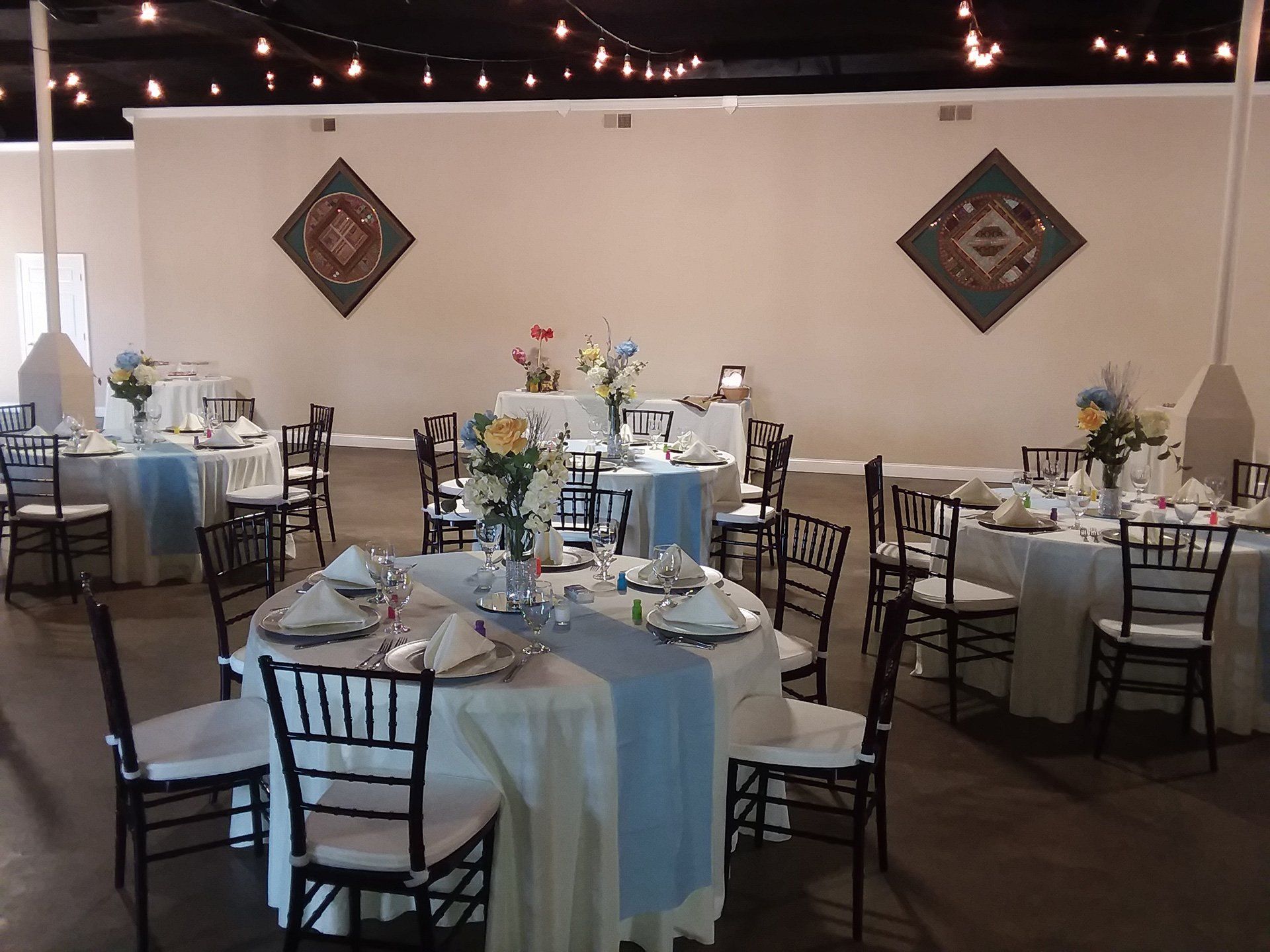 room of round tables set with floral centerpieces