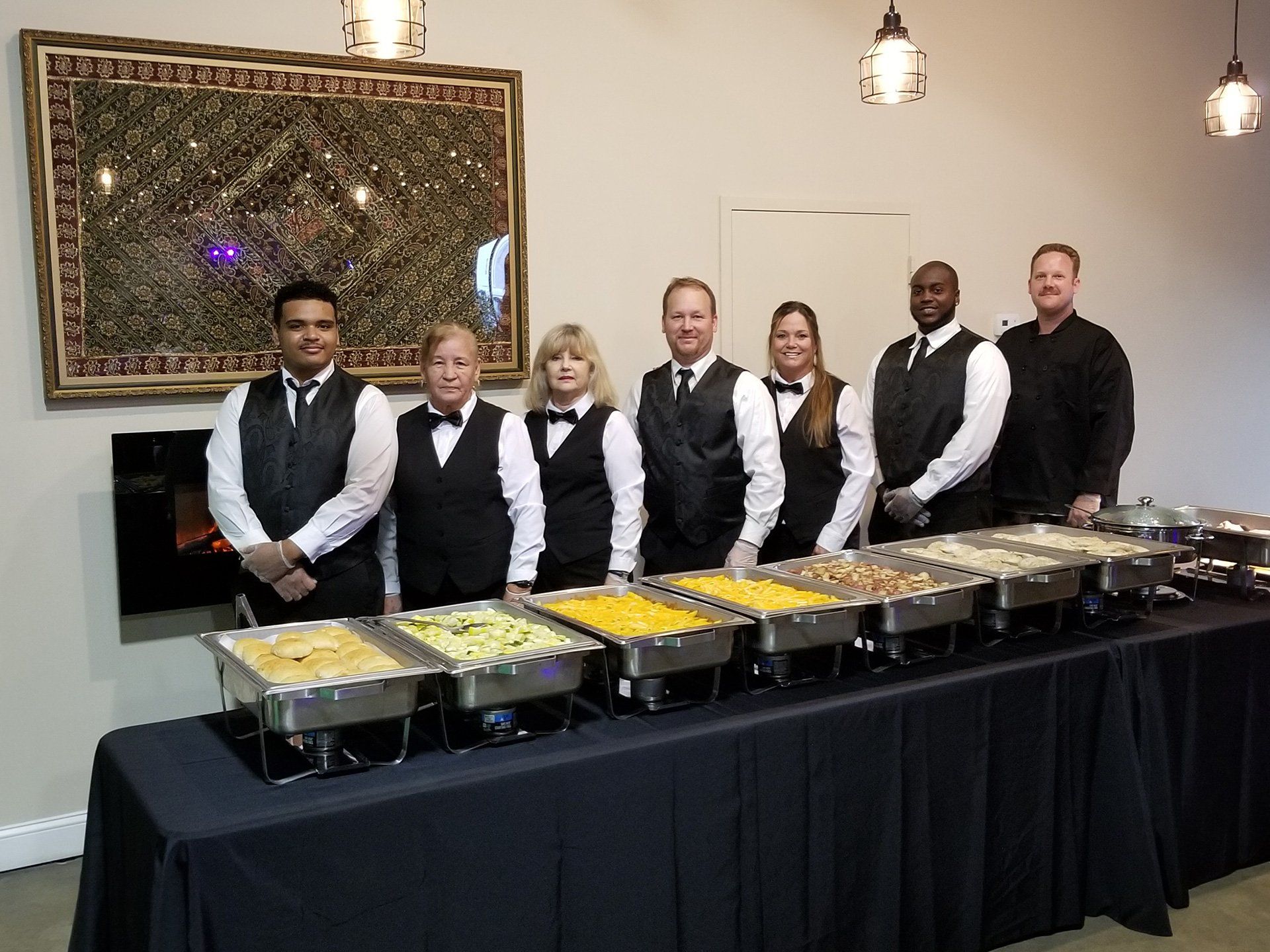 group of caterers standing behind a buffet table