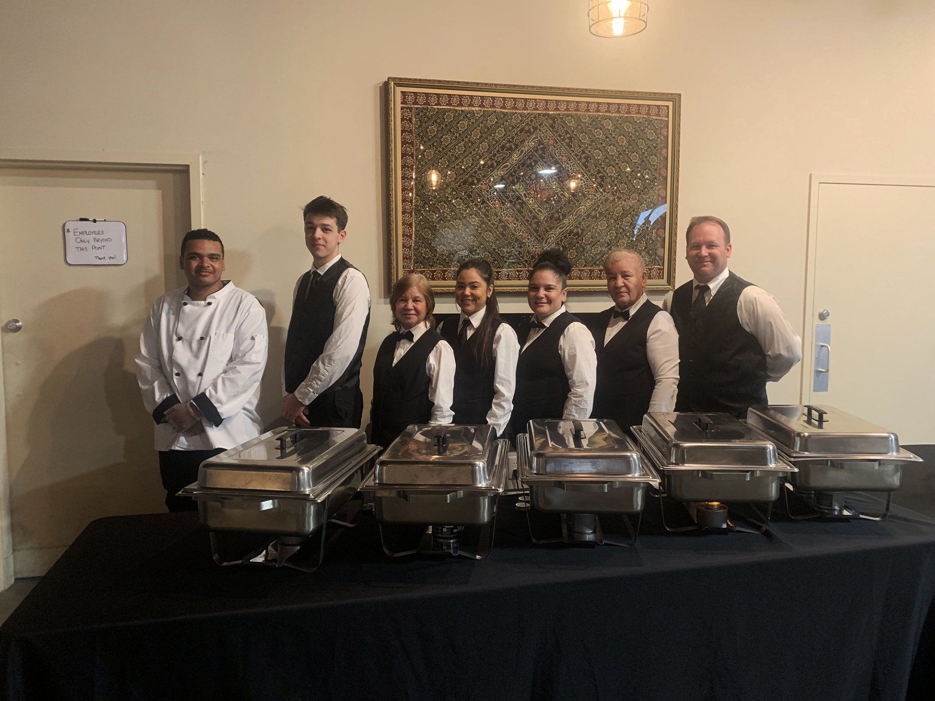 caterers standing in behind buffet table