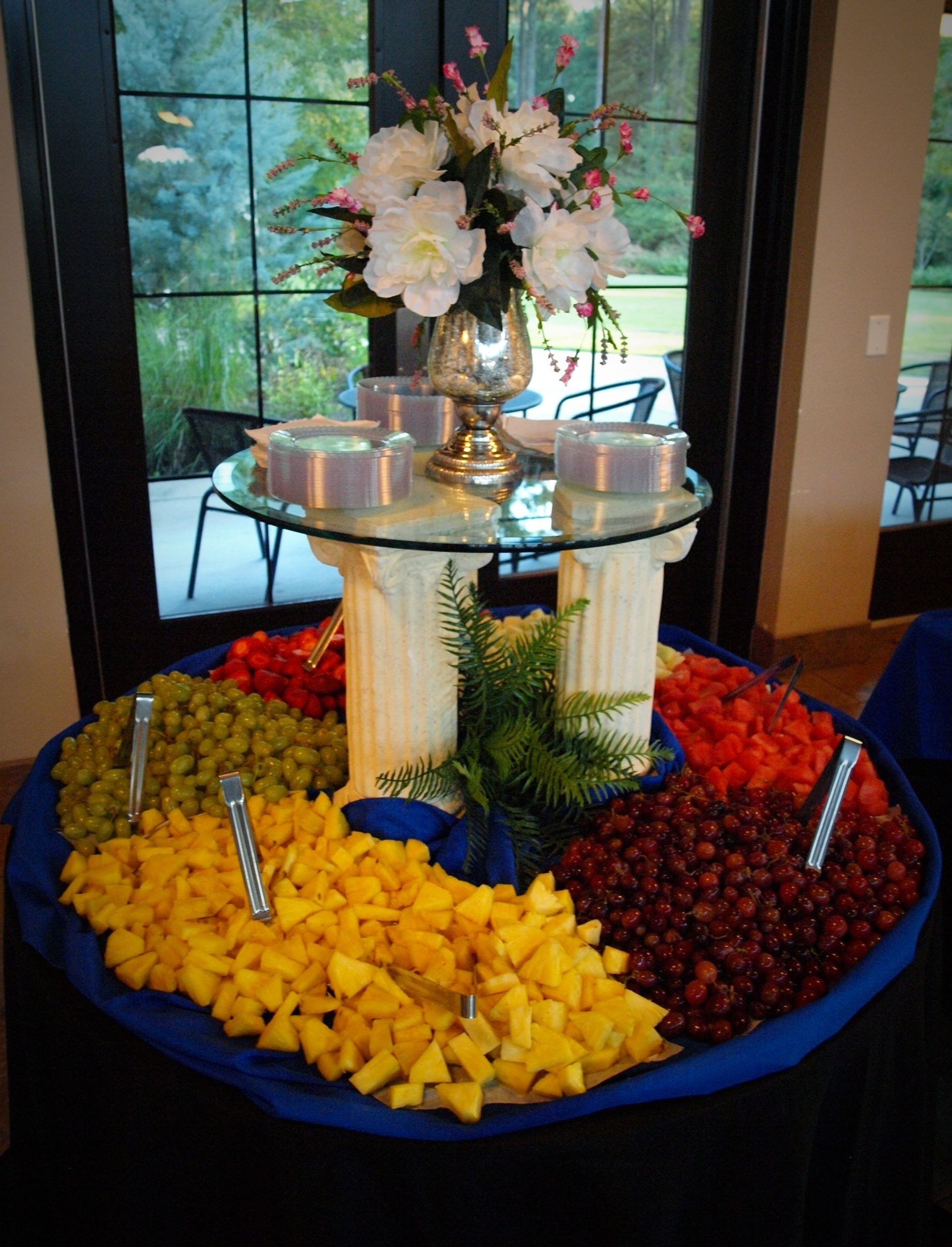 tiered fruit display with floral arrangement on top