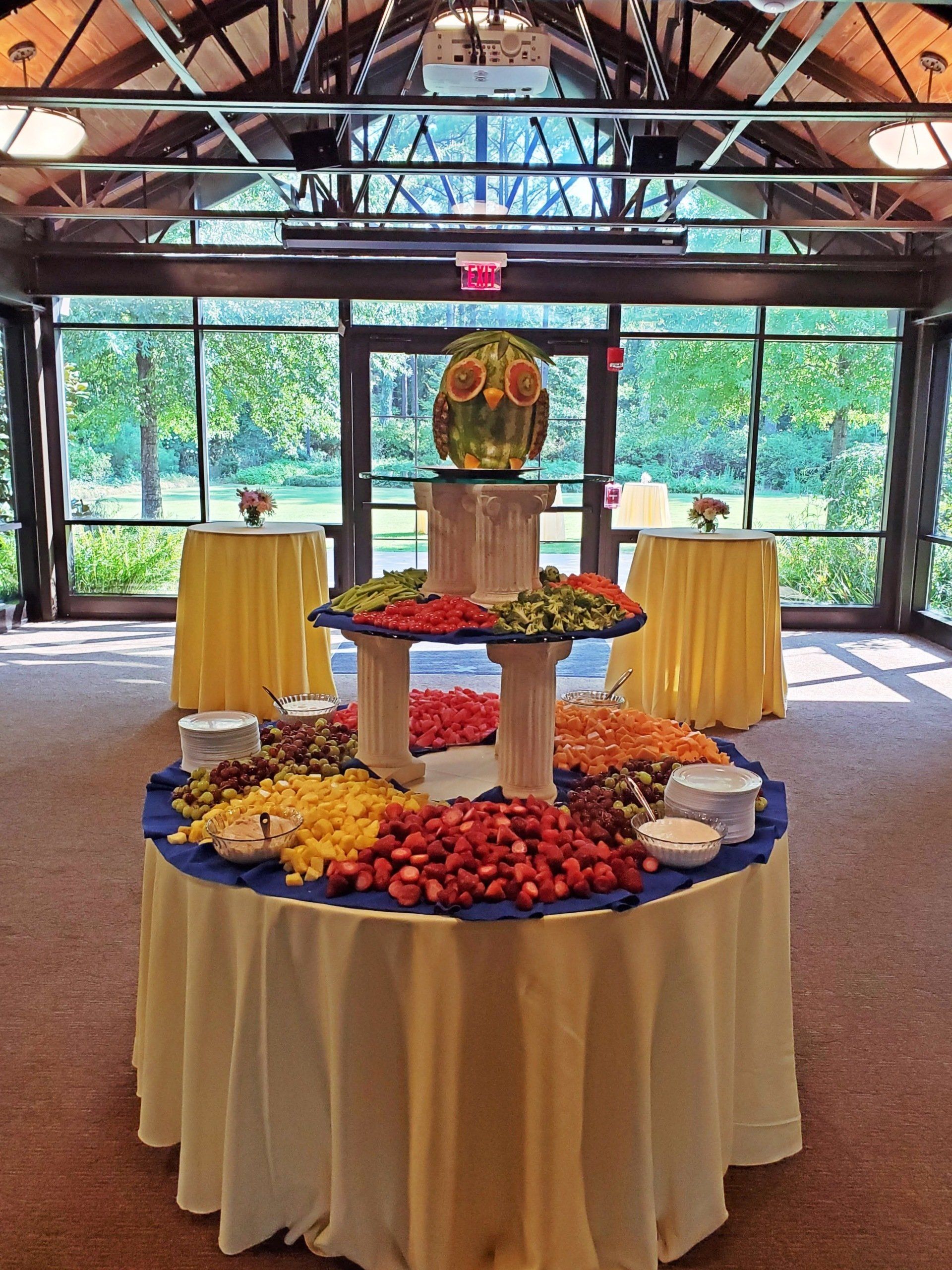 3 tiered fruit and vegetable display with a fruit owl display on top
