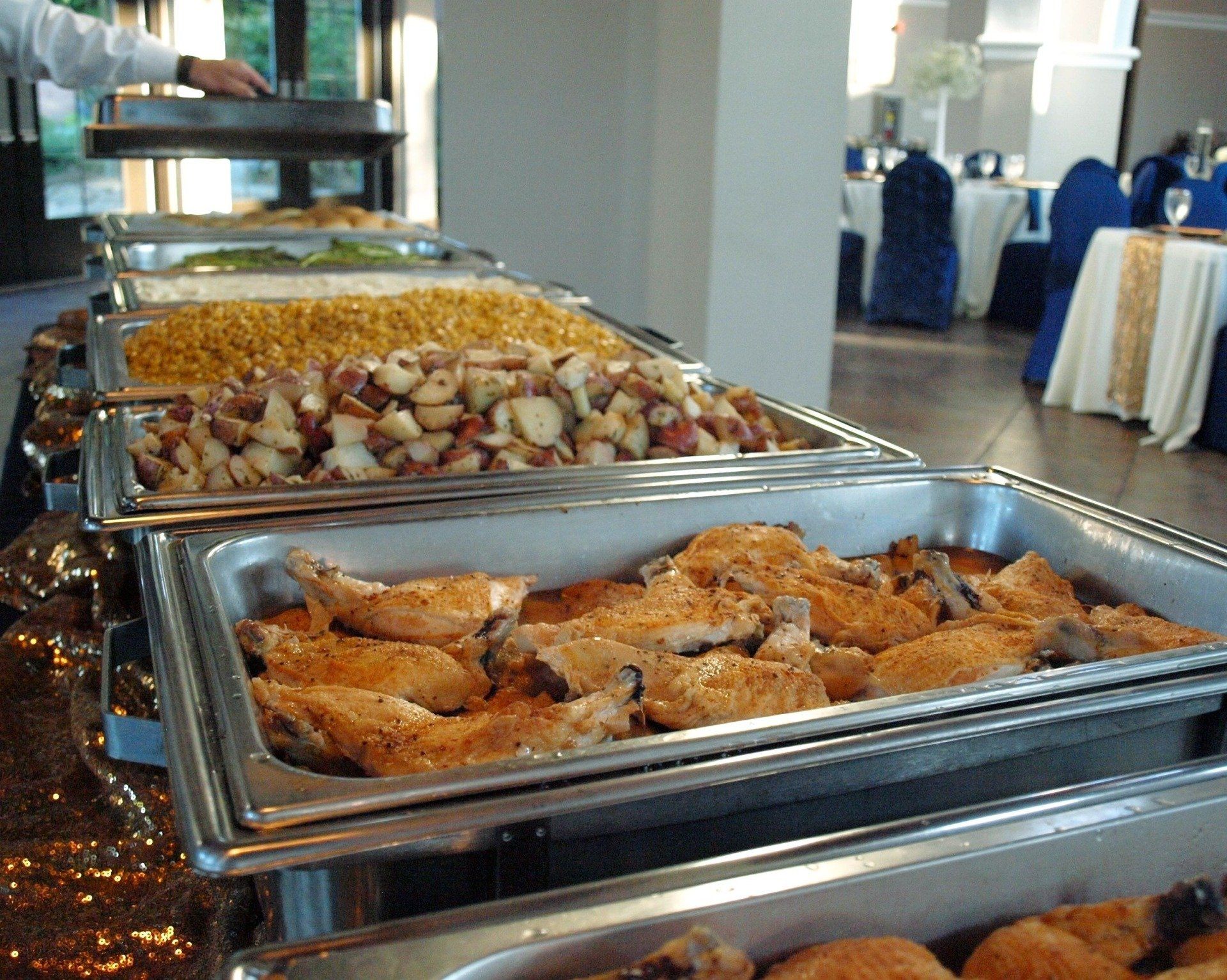 buffet pans filled with food lined up on table