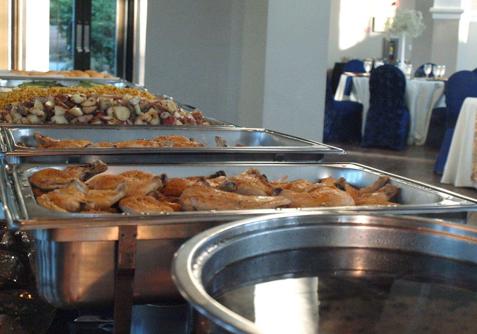 buffet pans filled with food lined up on table