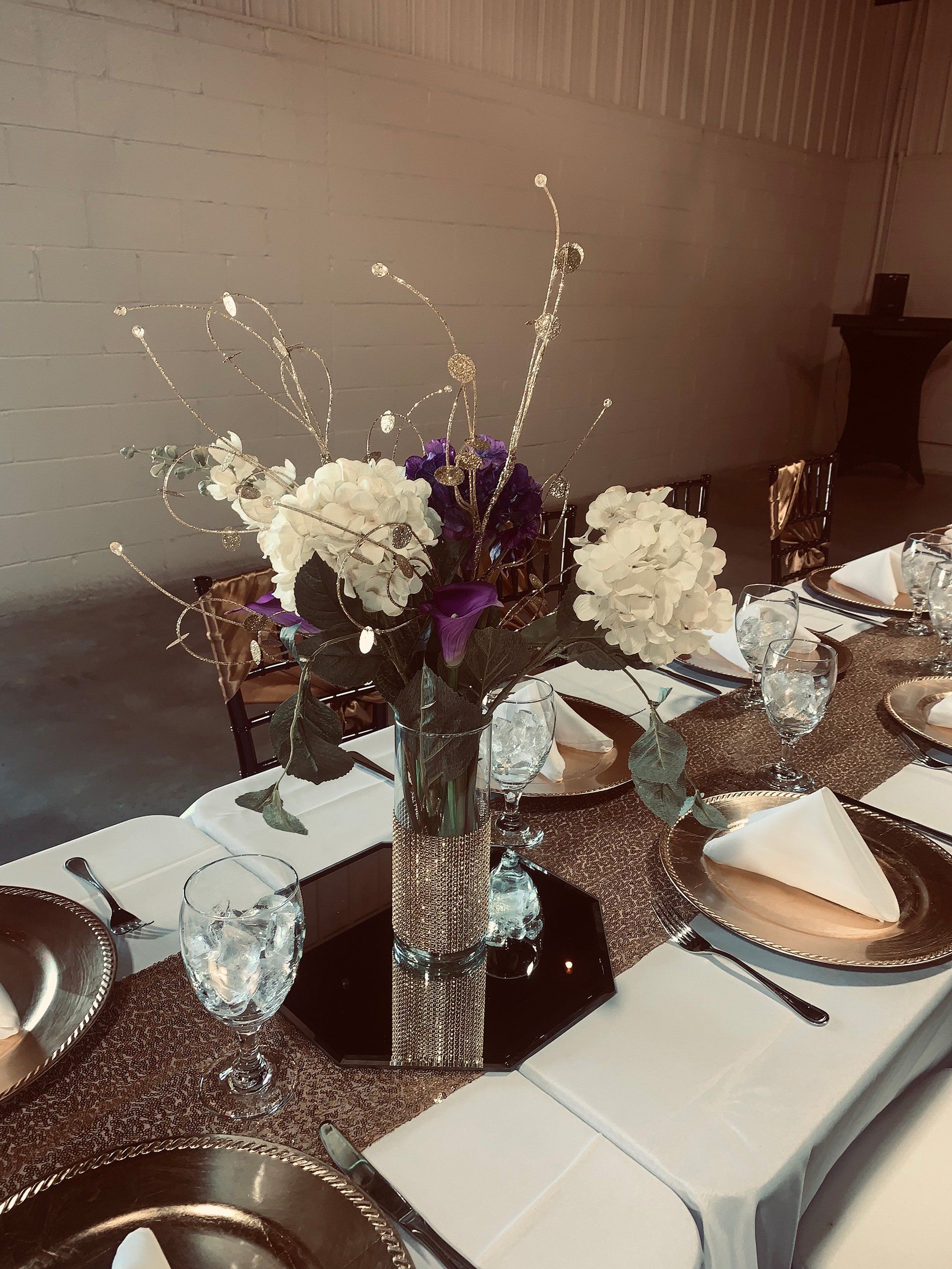 long rectangular table with gold decor and floral centerpiece