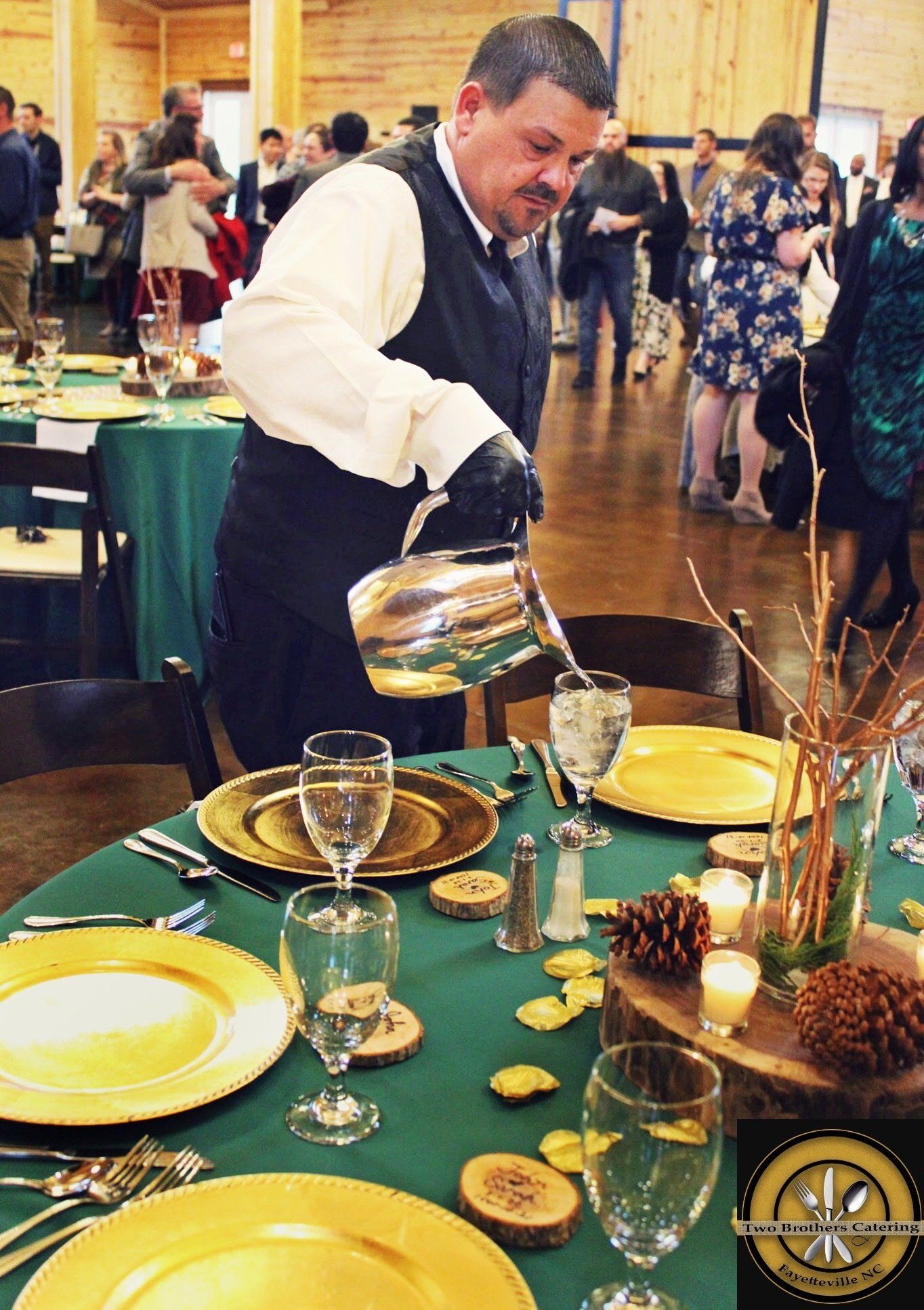 male caterer filling water glasses