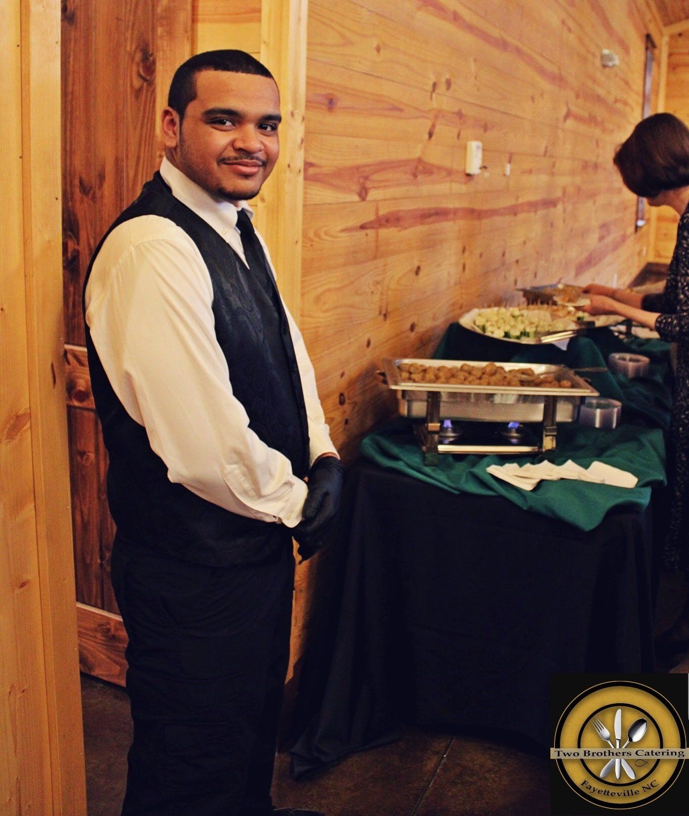 male caterer standing next to a buffet table