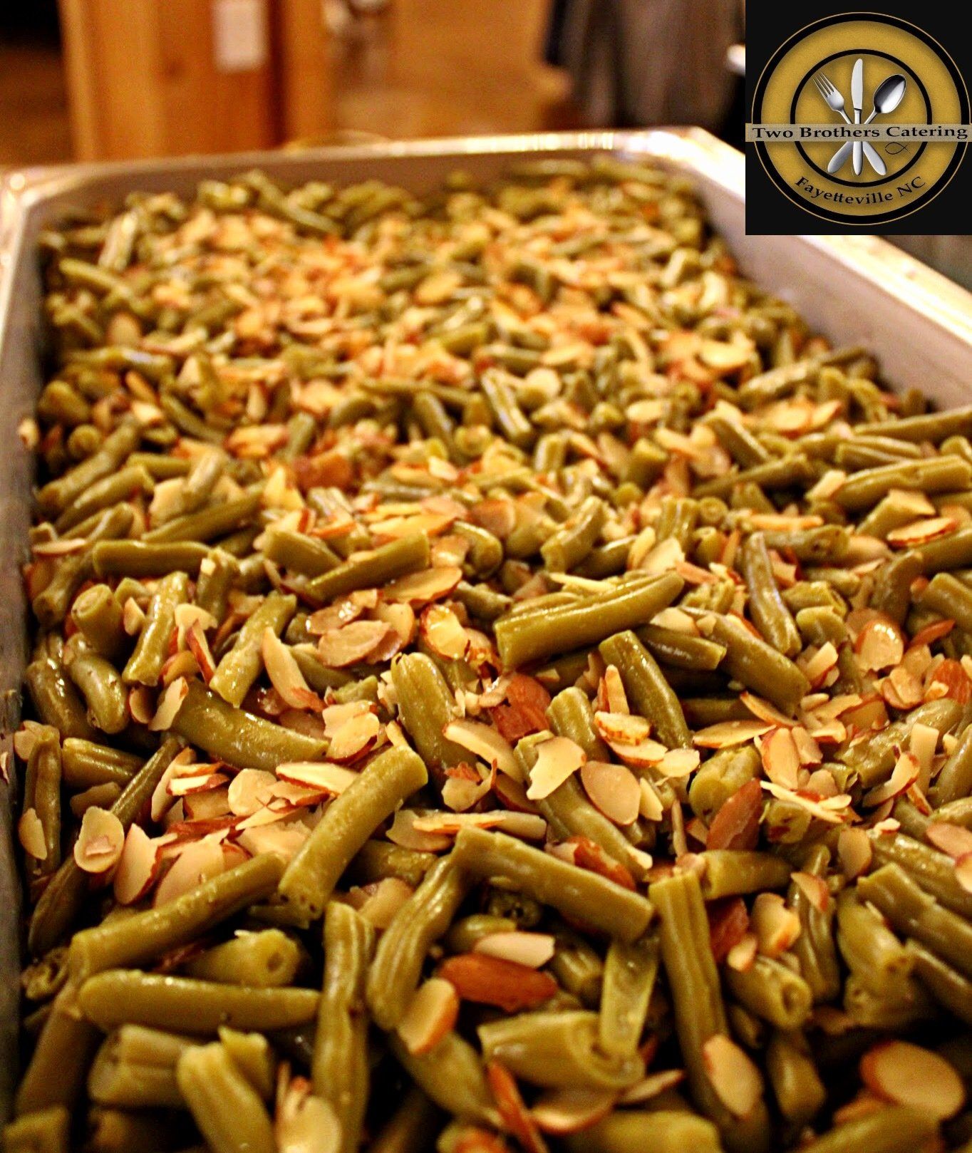 buffet tray filled with green beans and almond slivers