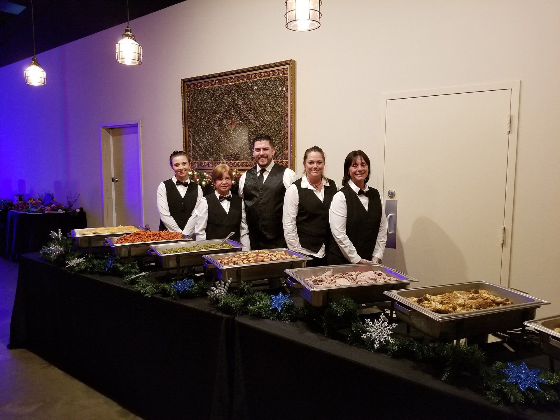 group of caterers standing behind a buffet table