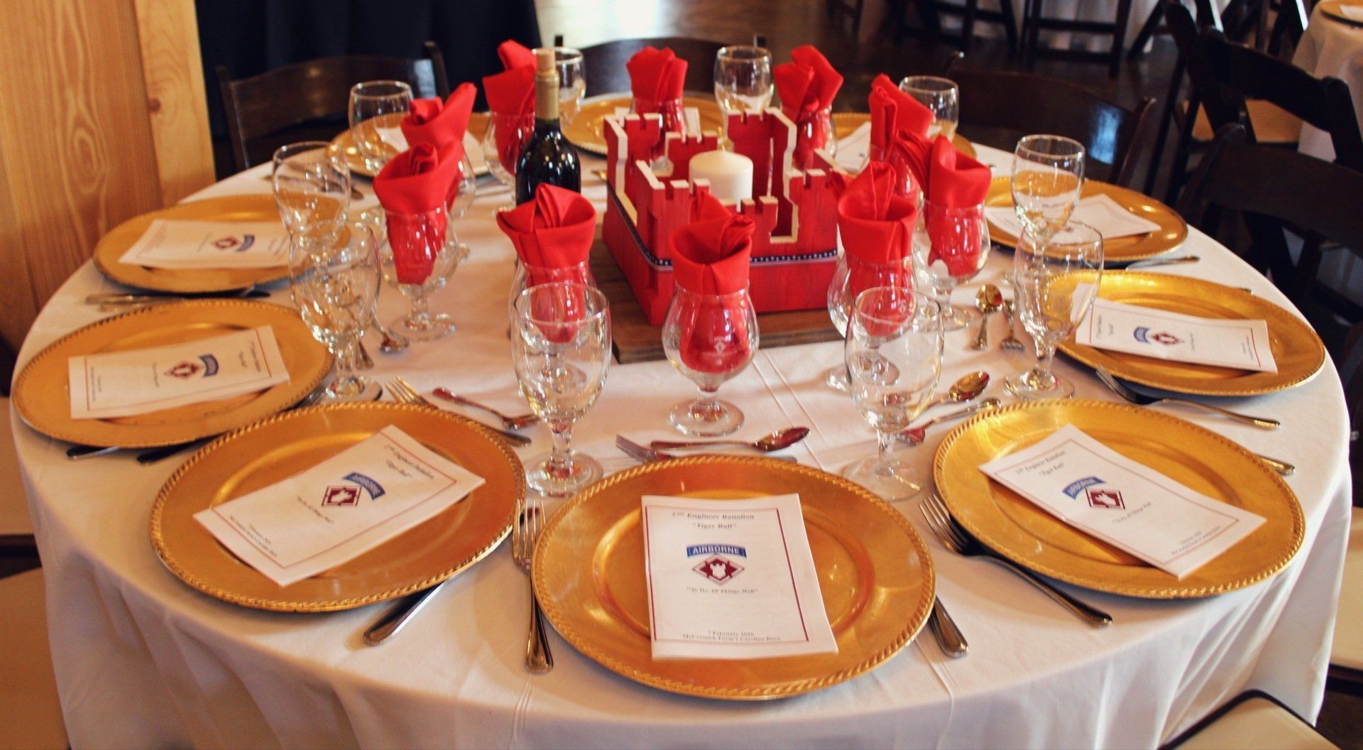 round table set with red and gold decor