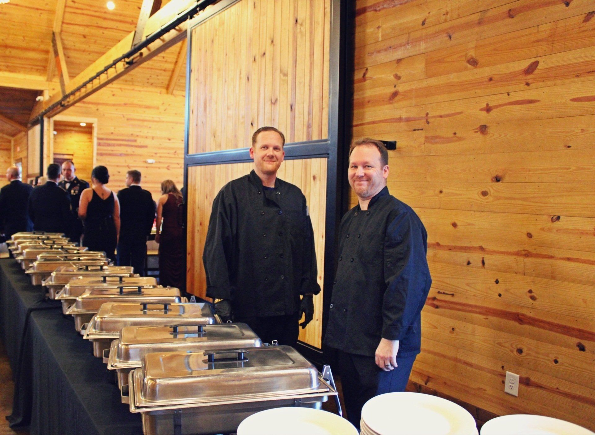 2 male caterers standing behind a buffet table at the Military Balls venue